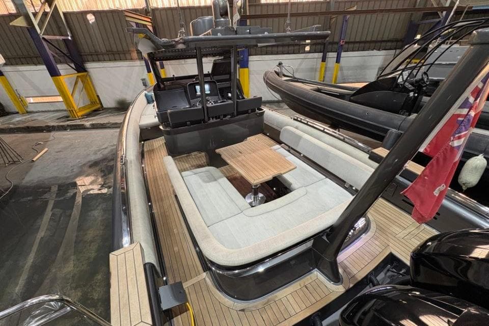 2021 Novamarine Black Shiver 100 yacht interior with seating and table in a warehouse.