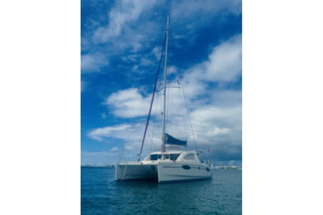 Sailing catamaran Leopard 39, 2011 model, anchored under a vibrant blue sky.