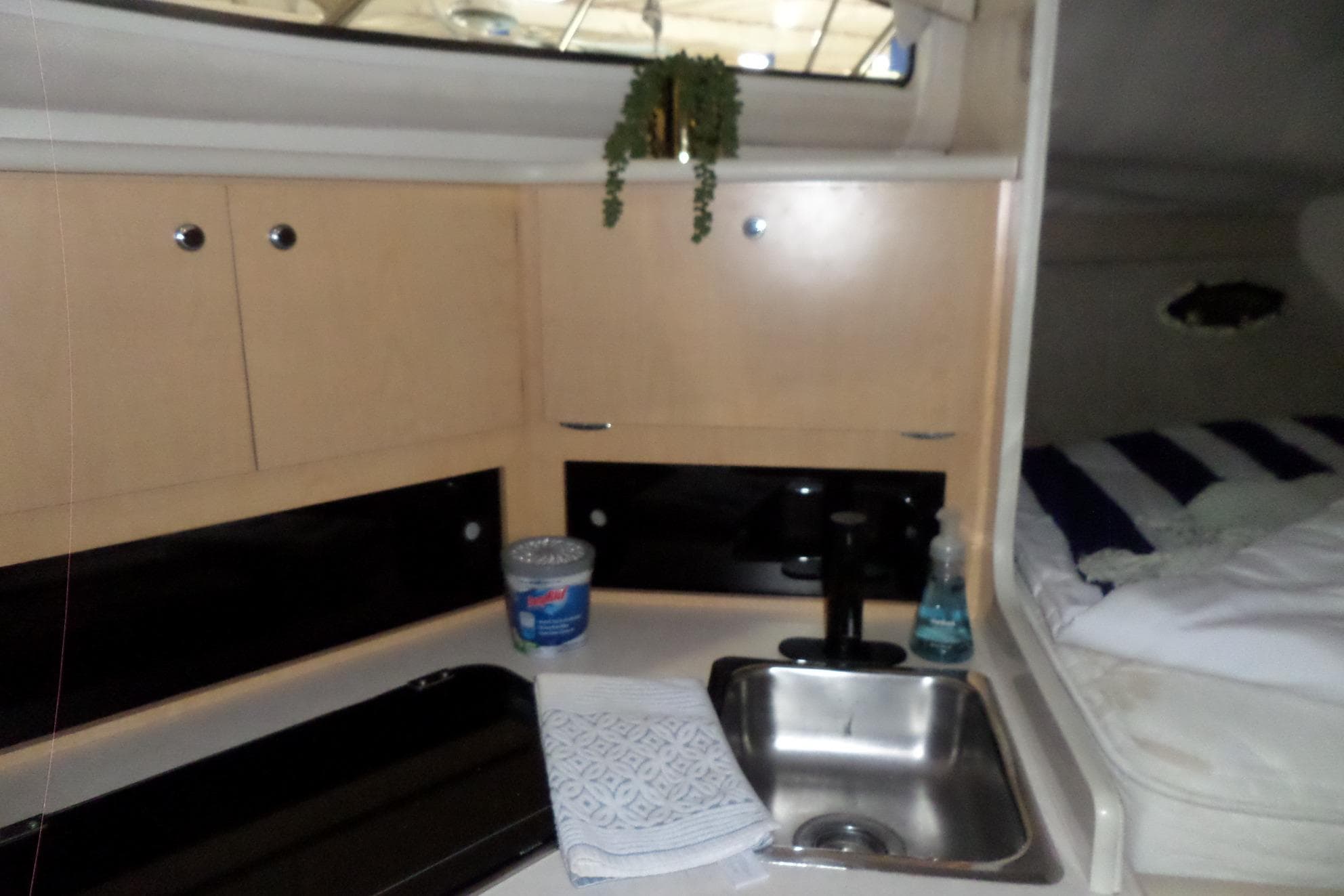 Interior of 2000 Bayliner 3055 Ciera showing kitchenette with sink and cabinets.