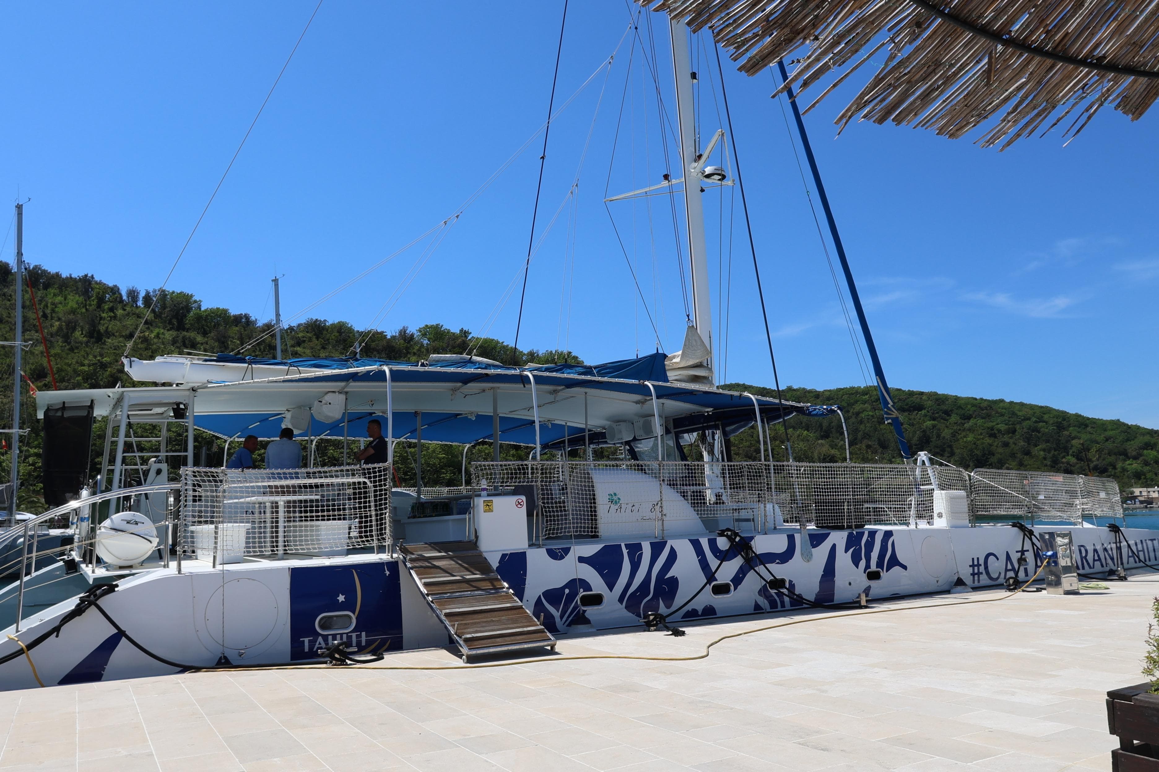 2015 Fountaine Pajot Taiti Day Charter 80 catamaran docked, featuring blue and white design.