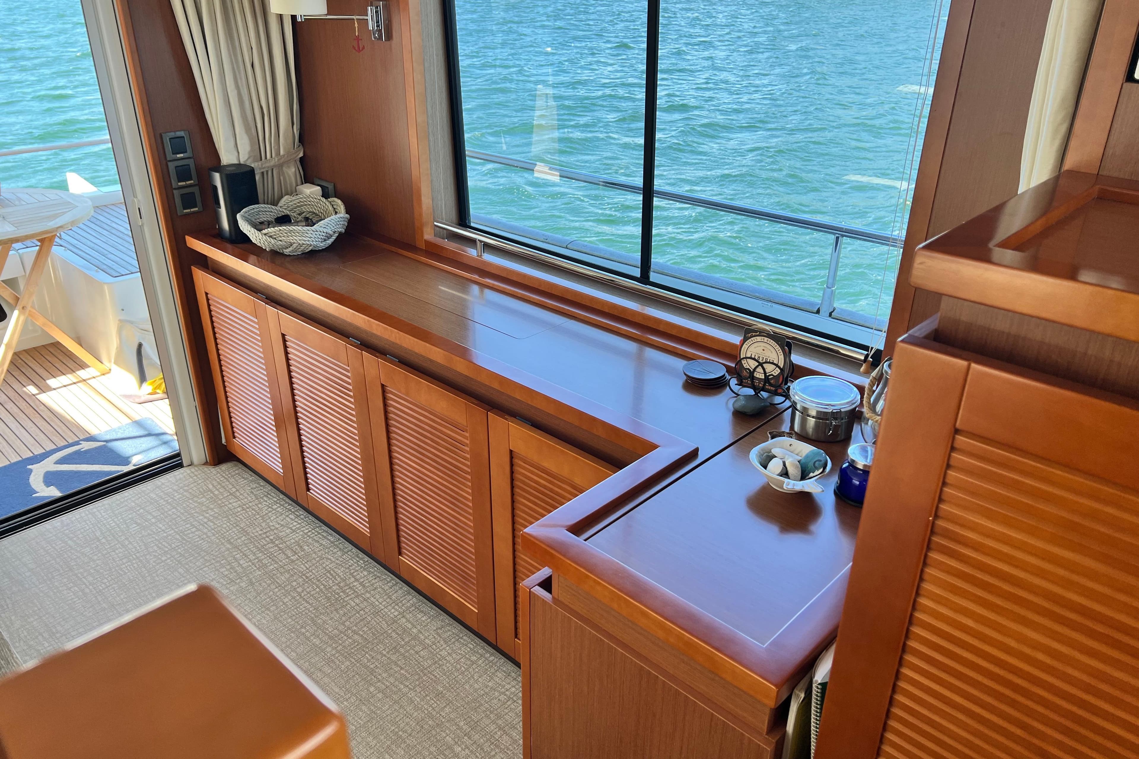 Luxurious interior of 2014 Beneteau Swift Trawler 50 with wooden cabinetry and ocean view.