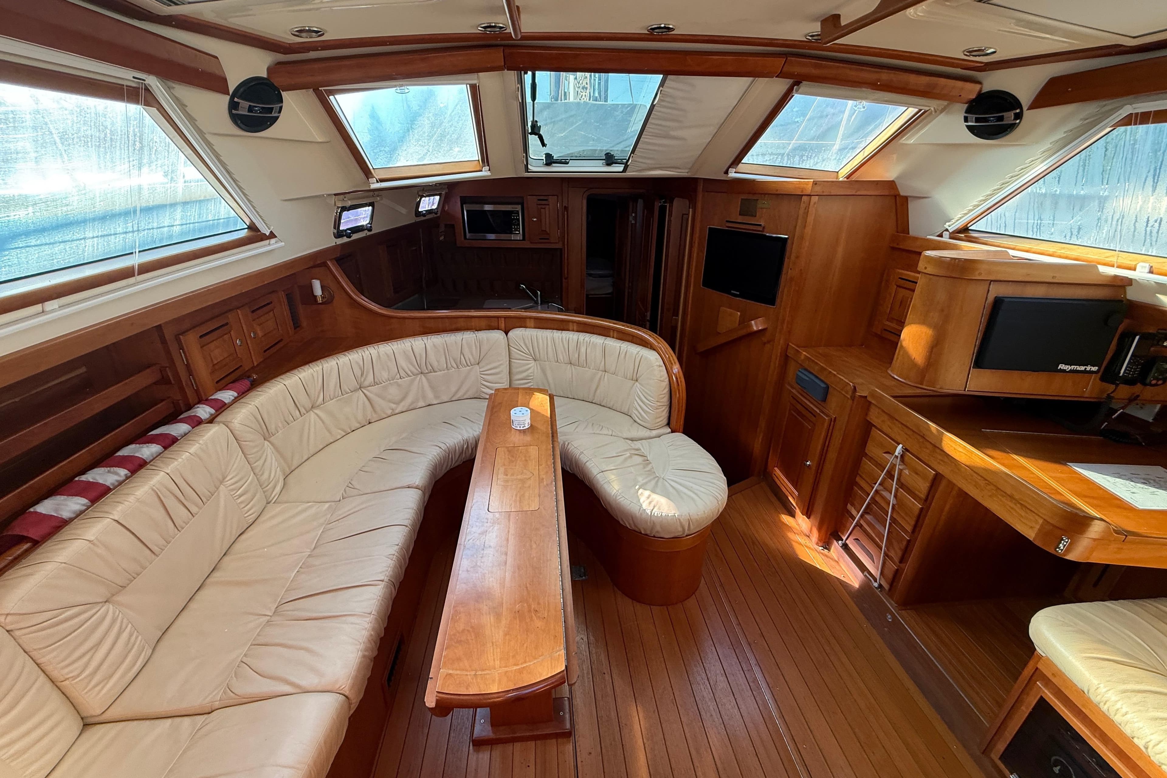 Luxurious interior of 2011 Tartan 4700 yacht with leather seating and wooden finishes.