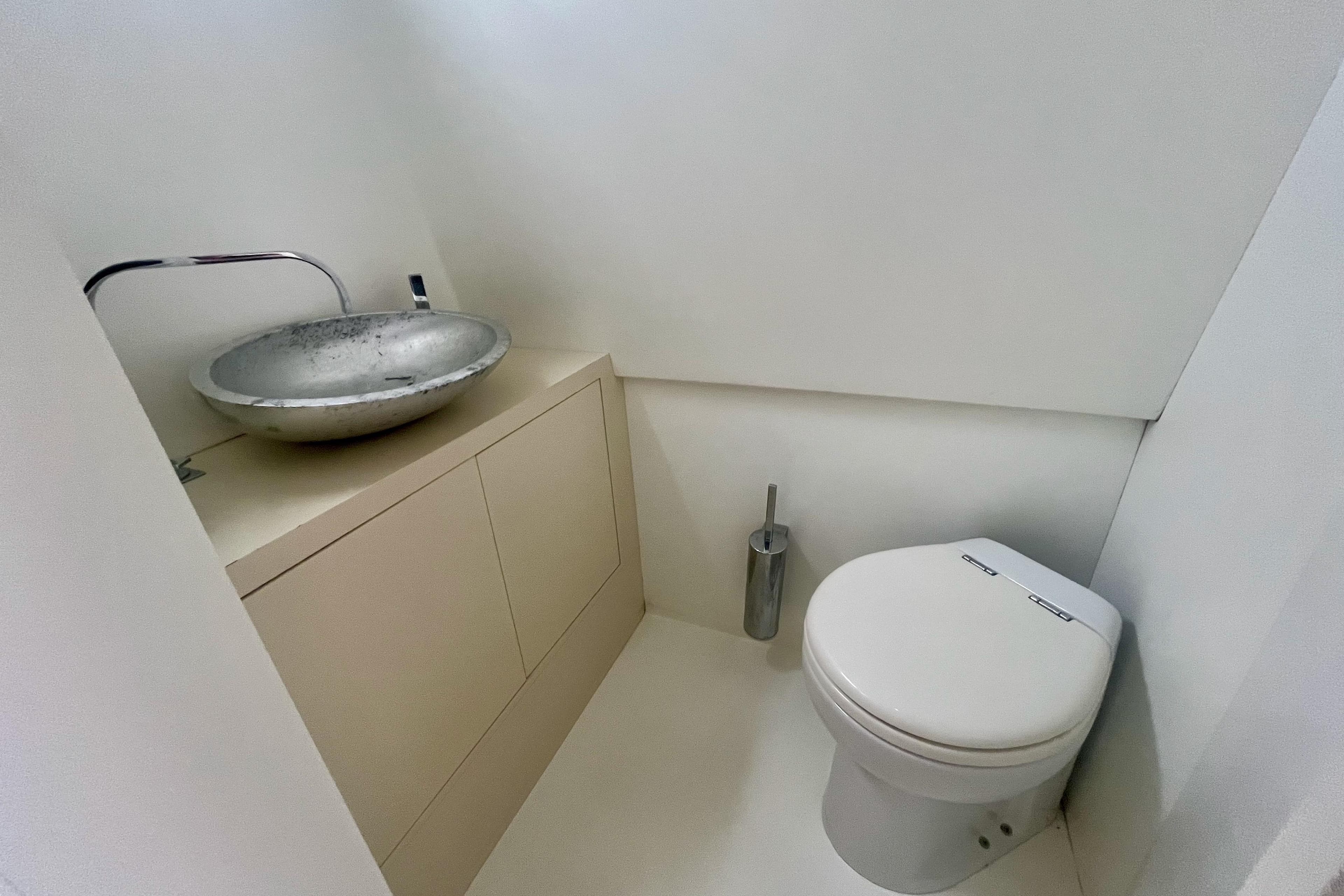 Compact bathroom with modern sink and toilet on a 2011 Maori 50 T-Top yacht.