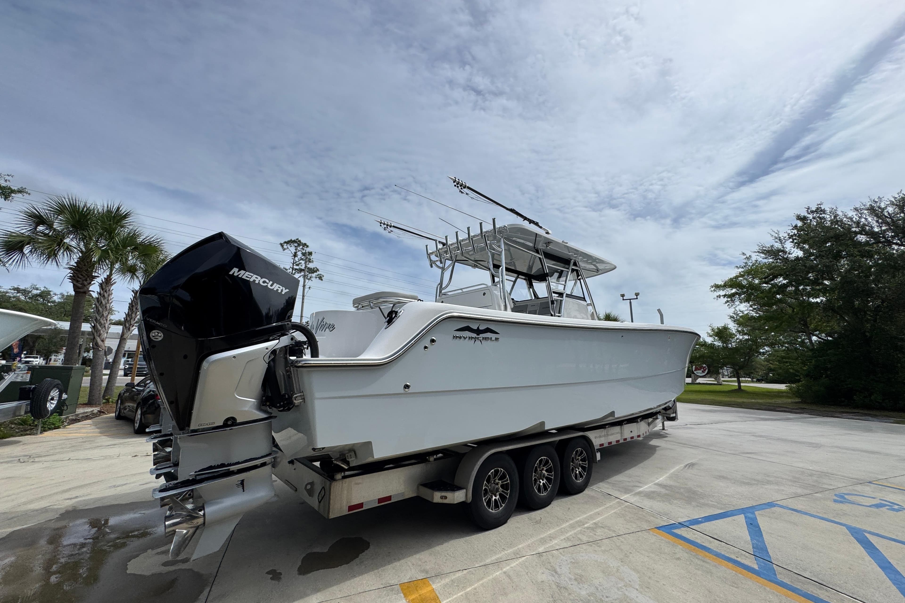 2020 Invincible 35 Catamaran on trailer with Mercury outboard engines, parked outdoors.