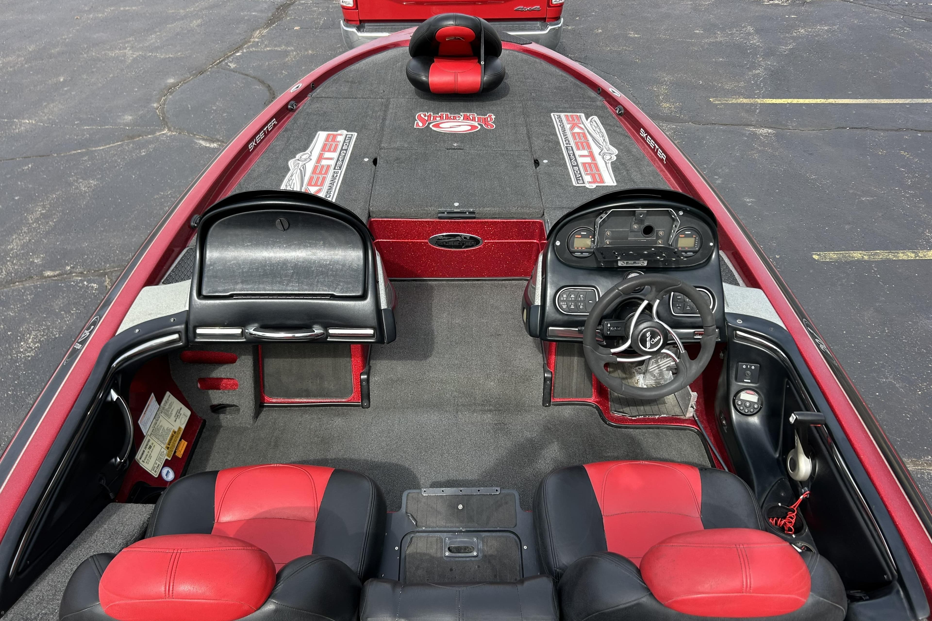 2007 Skeeter 20i boat interior with red and black seating, dashboard, and steering wheel.