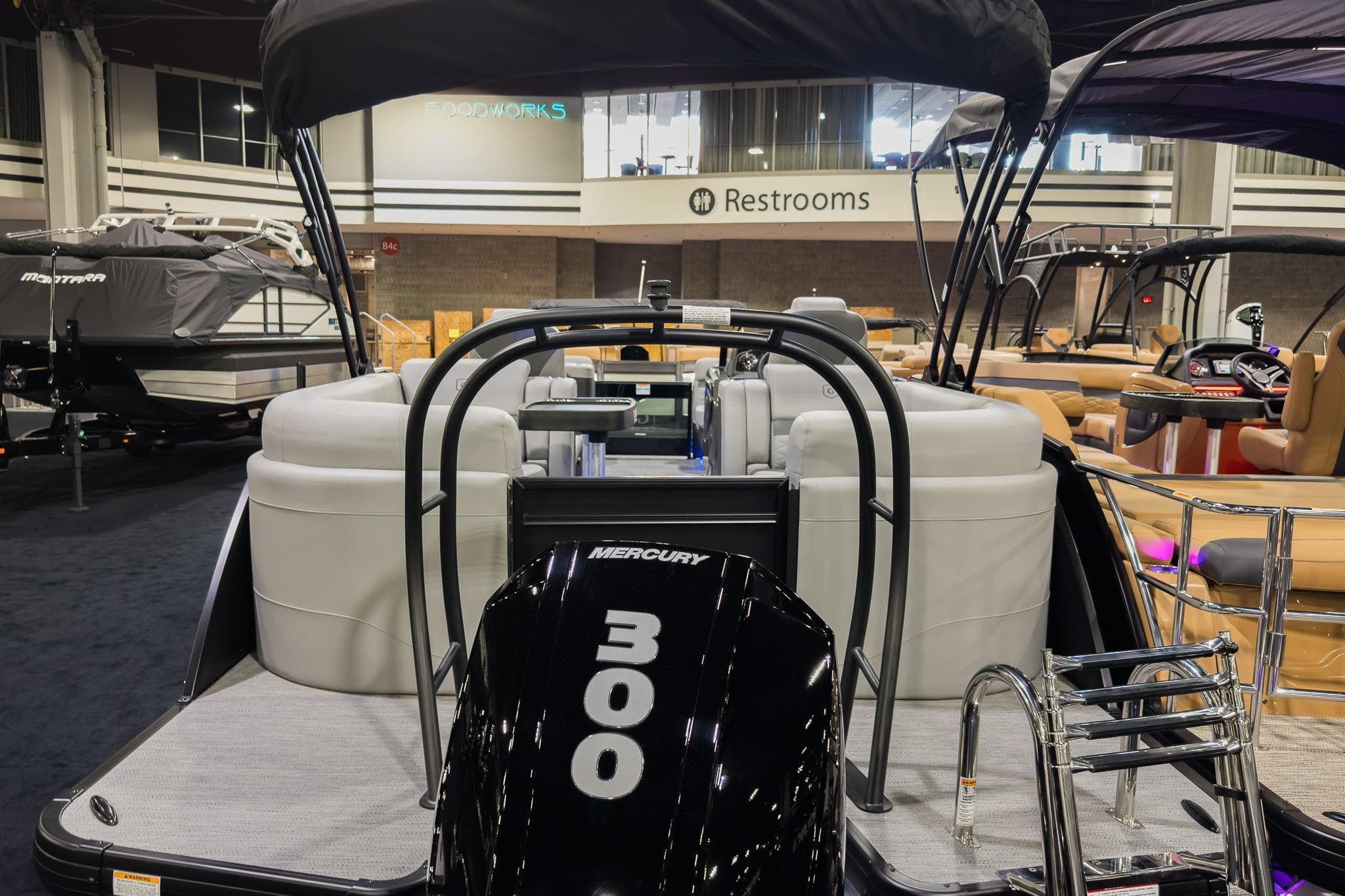 2026 Godfrey Monaco 235 Split Bench boat with Mercury 300 engine at indoor showroom.