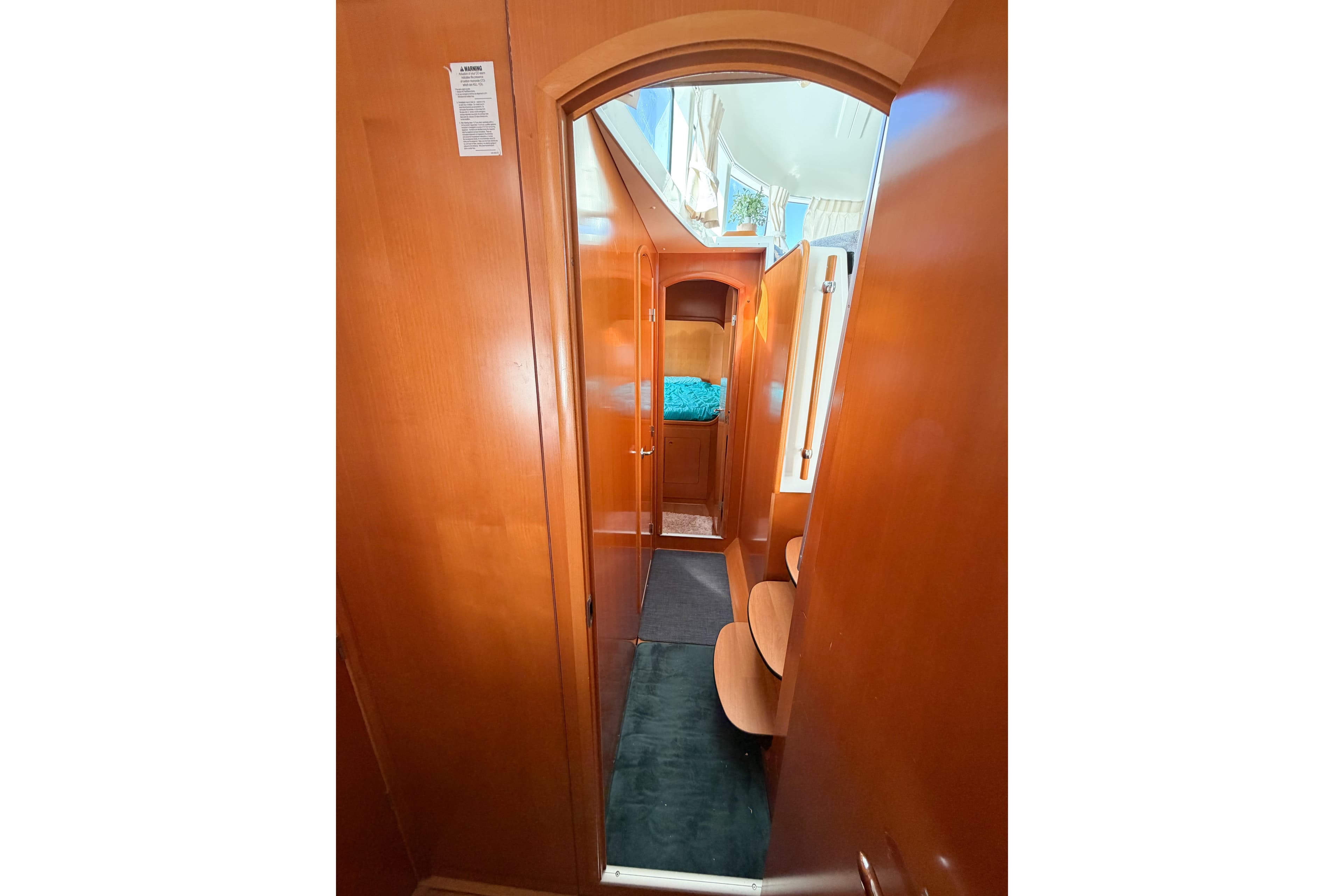 Interior view of 2005 Lagoon 380 S2 yacht, featuring wooden cabinetry and cozy sleeping area.