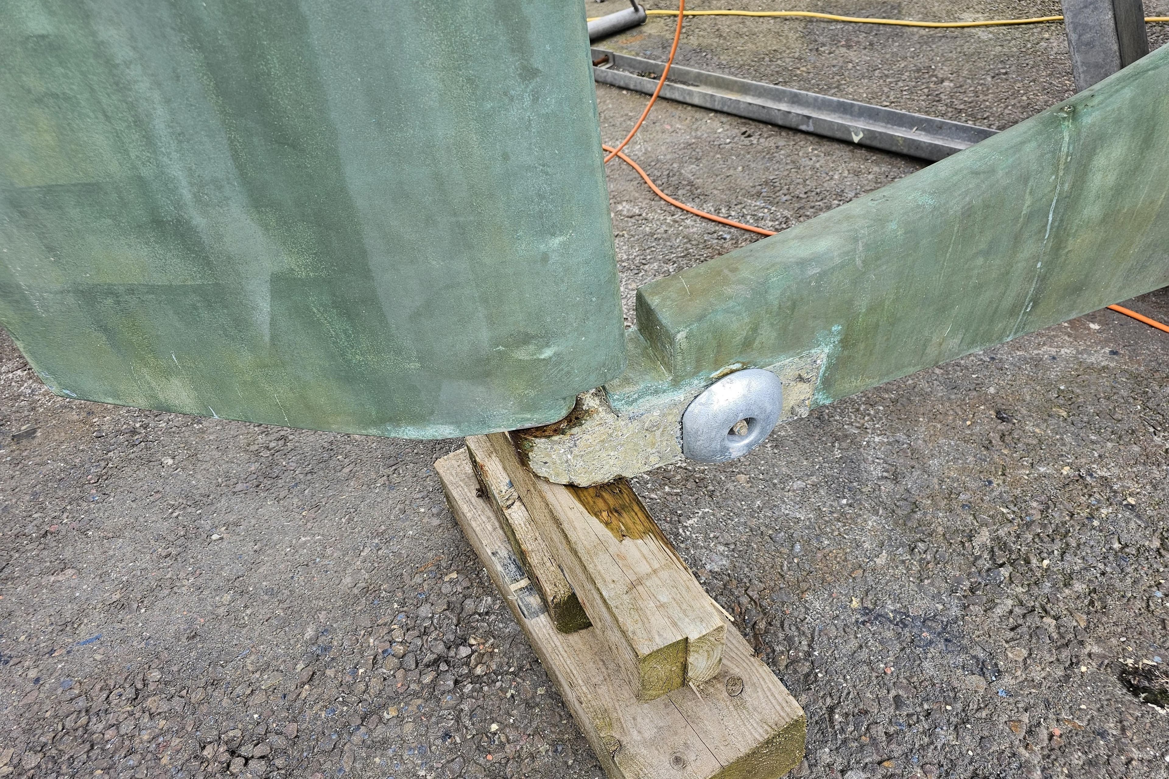 Rudder of 1992 Northshore Yachts Vancouver 34 on wooden blocks, showing marine wear.