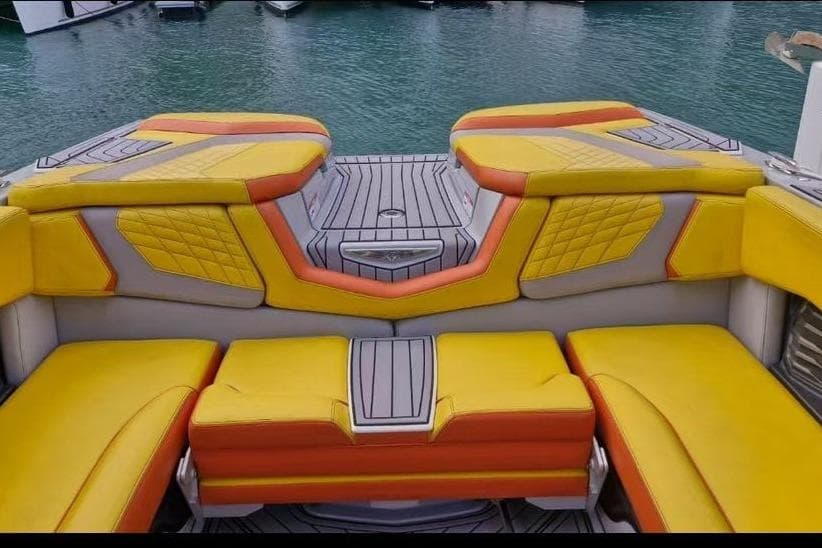 2022 Nautique Super Air Nautique G25 boat interior with vibrant yellow and orange seating.