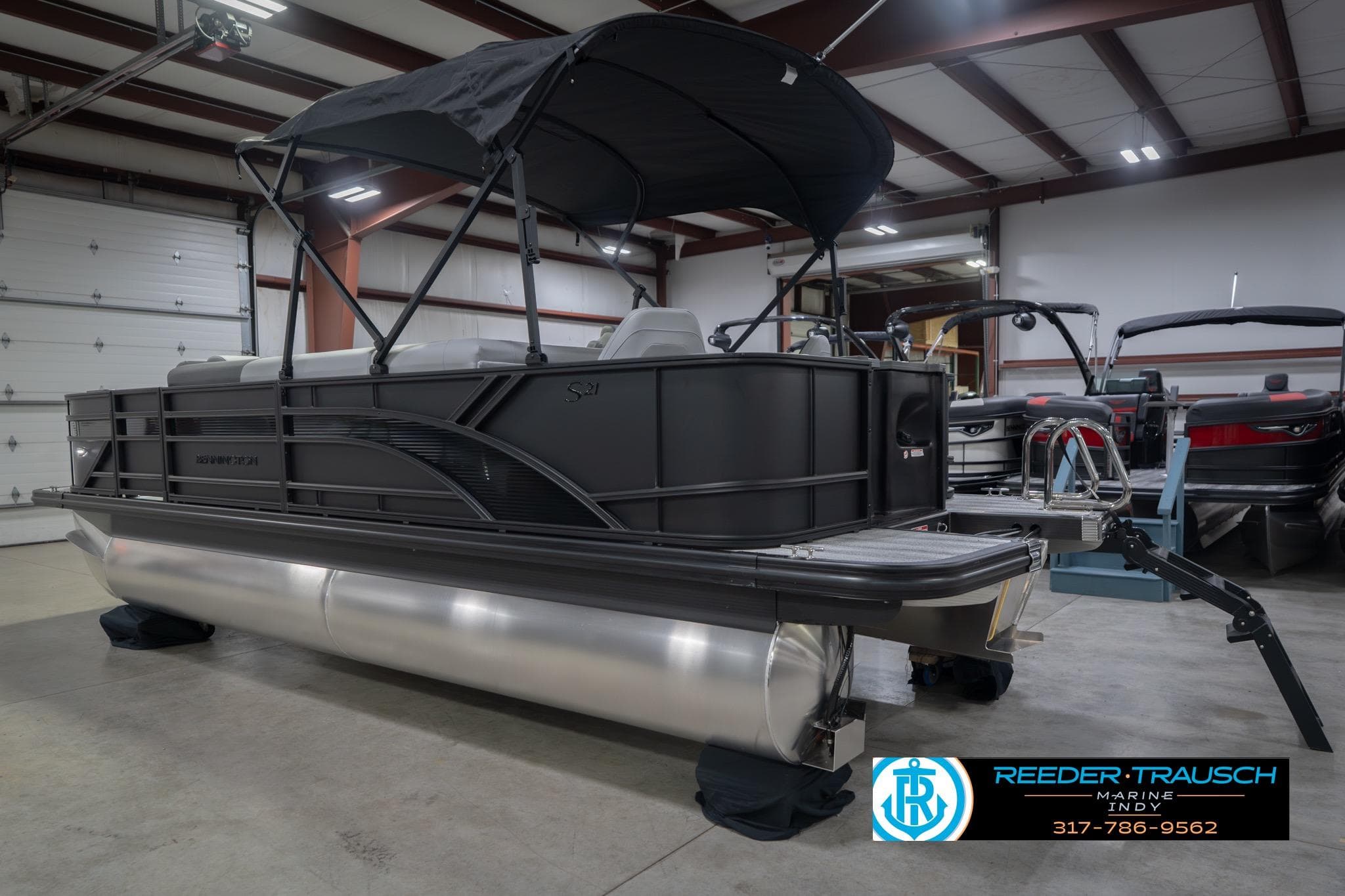 2026 Bennington 21 SF pontoon boat in showroom with canopy and sleek design.