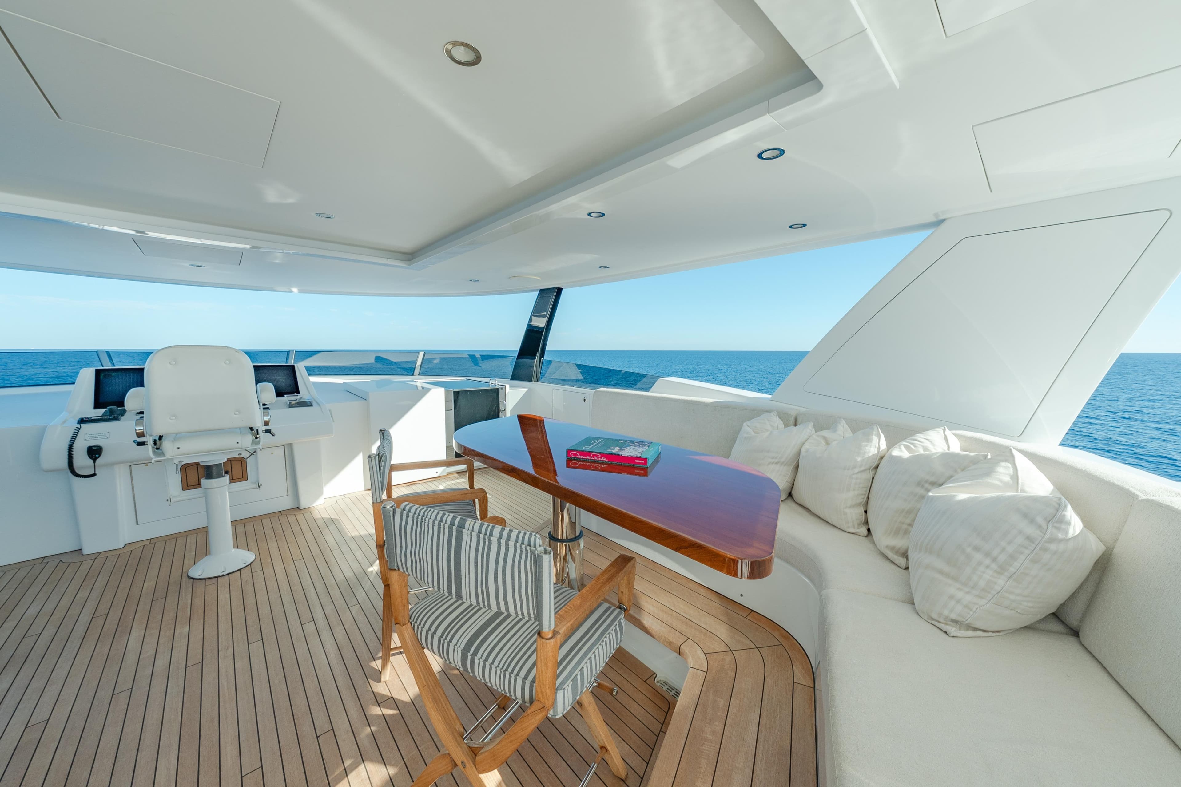 Luxurious 2018 Westport Raised Pilothouse yacht deck with seating, table, and ocean view.