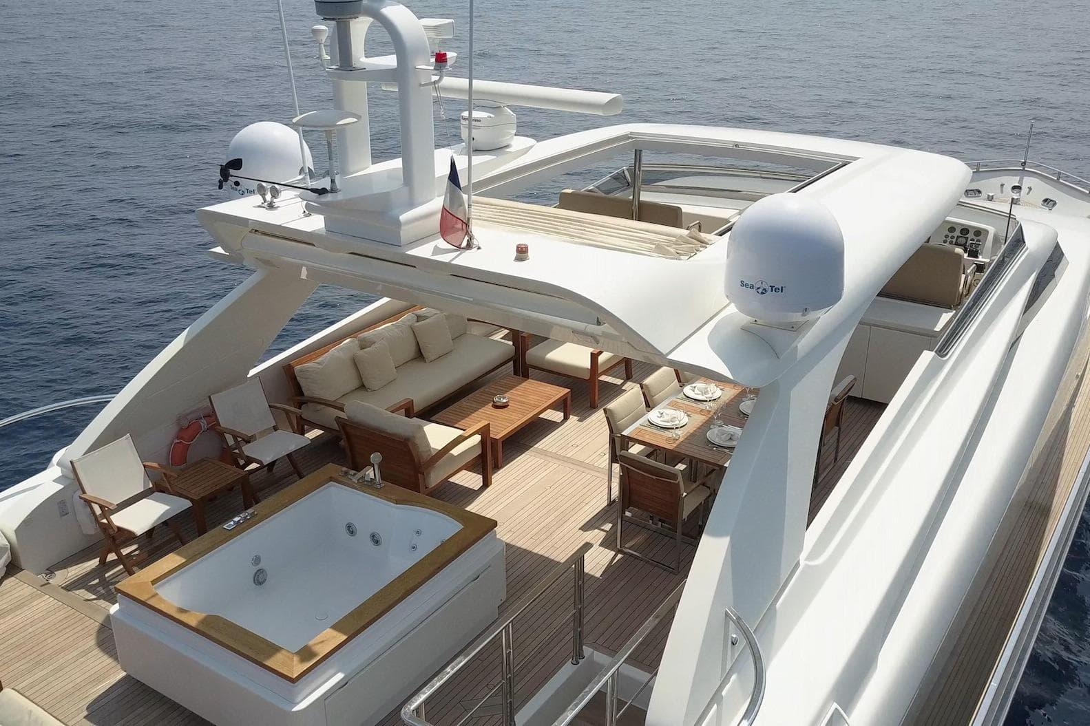 Luxurious 2007 Sanlorenzo SL108 yacht deck with jacuzzi, seating, and dining area.