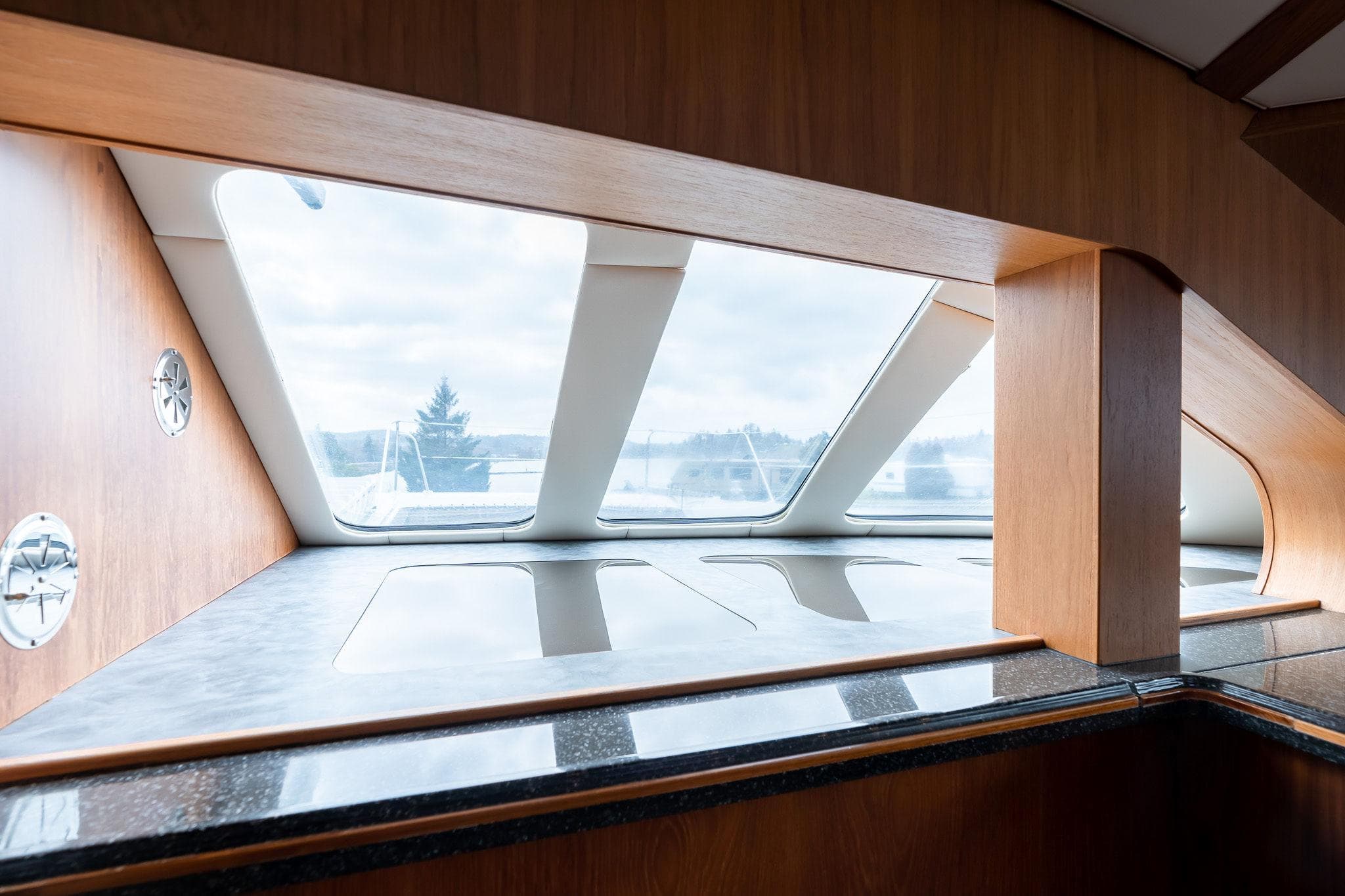 Interior view of 2025 Shuttleworth 52 AeroRig yacht, featuring sleek wooden design and large windows.