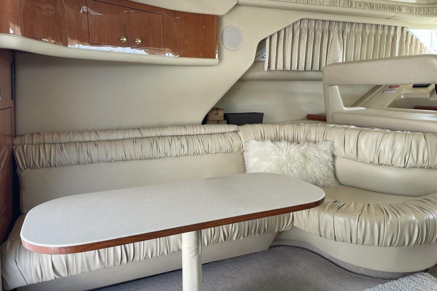 Luxurious interior of 2000 Sea Ray 400 Sedan Bridge with plush seating and table.