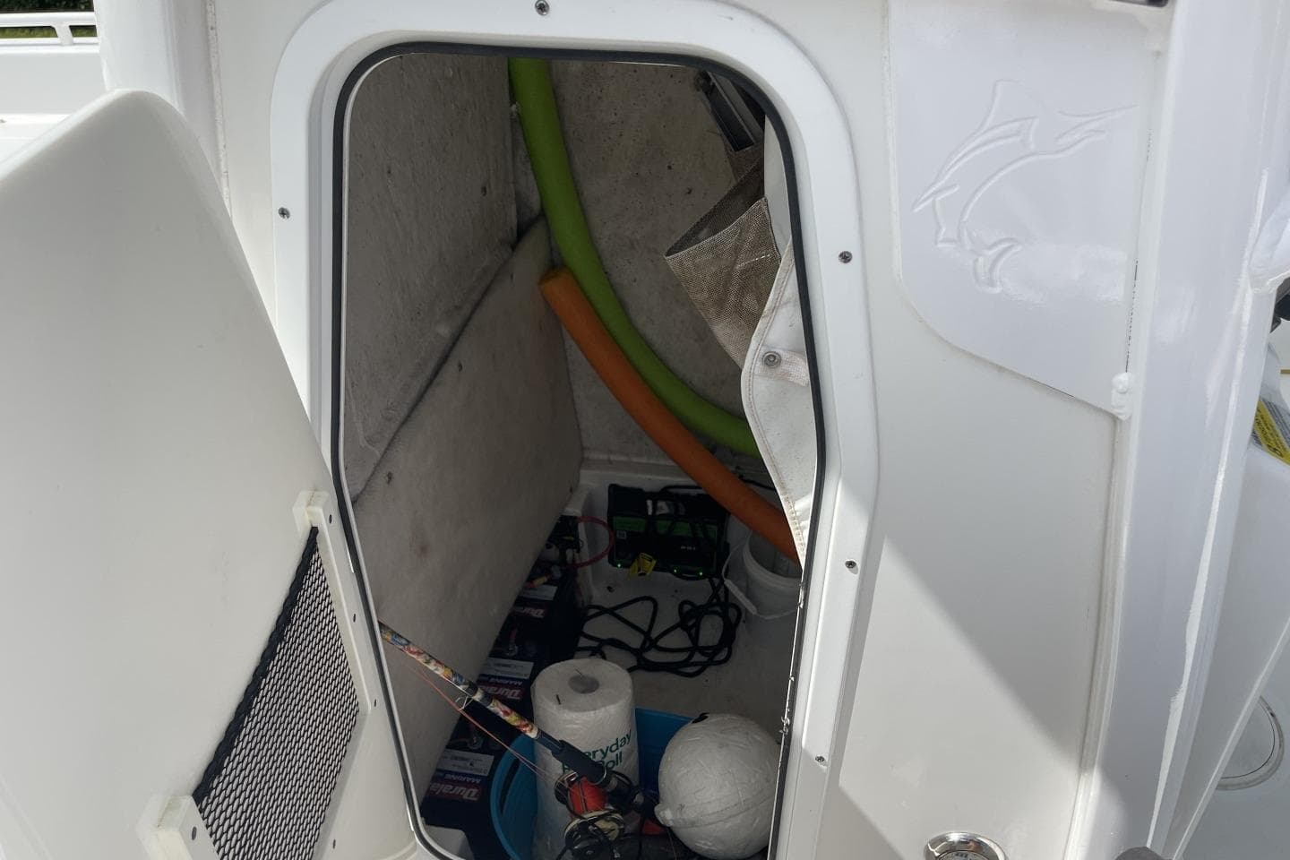 Storage compartment of a 2020 Sea Hunt BX 25 FS boat with various items inside.