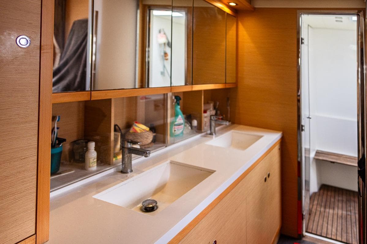 Luxurious bathroom interior of 2017 Lagoon 52 S yacht with dual sinks and wooden accents.