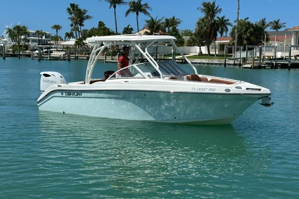 2019 Century 24 Resorter boat on clear blue water with palm trees in the background.