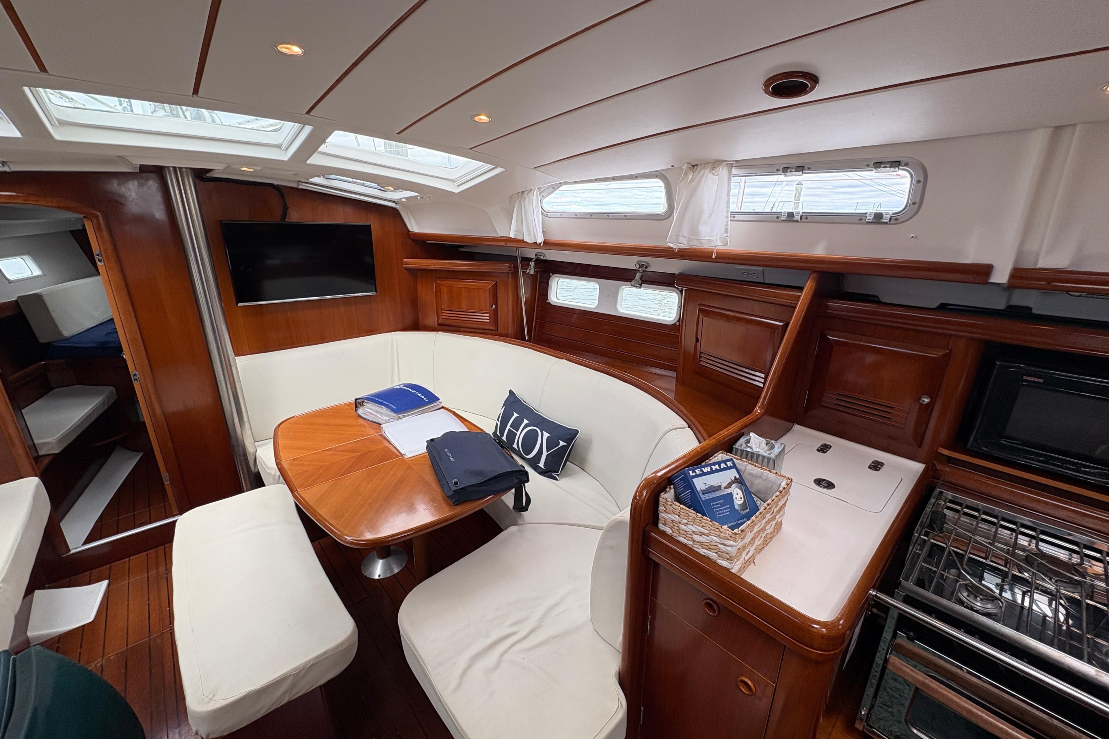 Interior of 2003 Beneteau 423 yacht with elegant wood finish and cozy seating area.