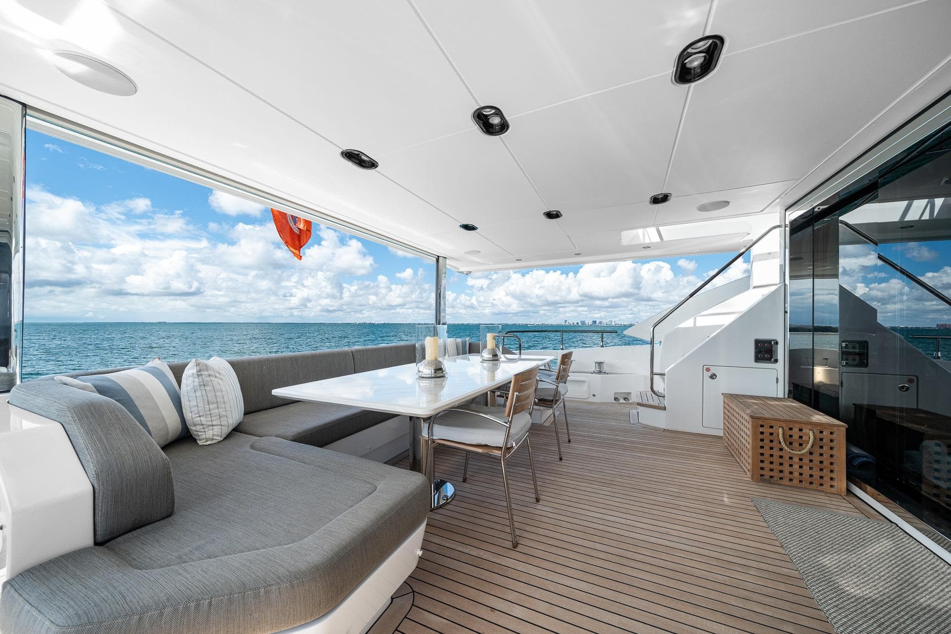 Luxurious Azimut Grande 27 METRI yacht deck with ocean view, featuring elegant seating and dining area.