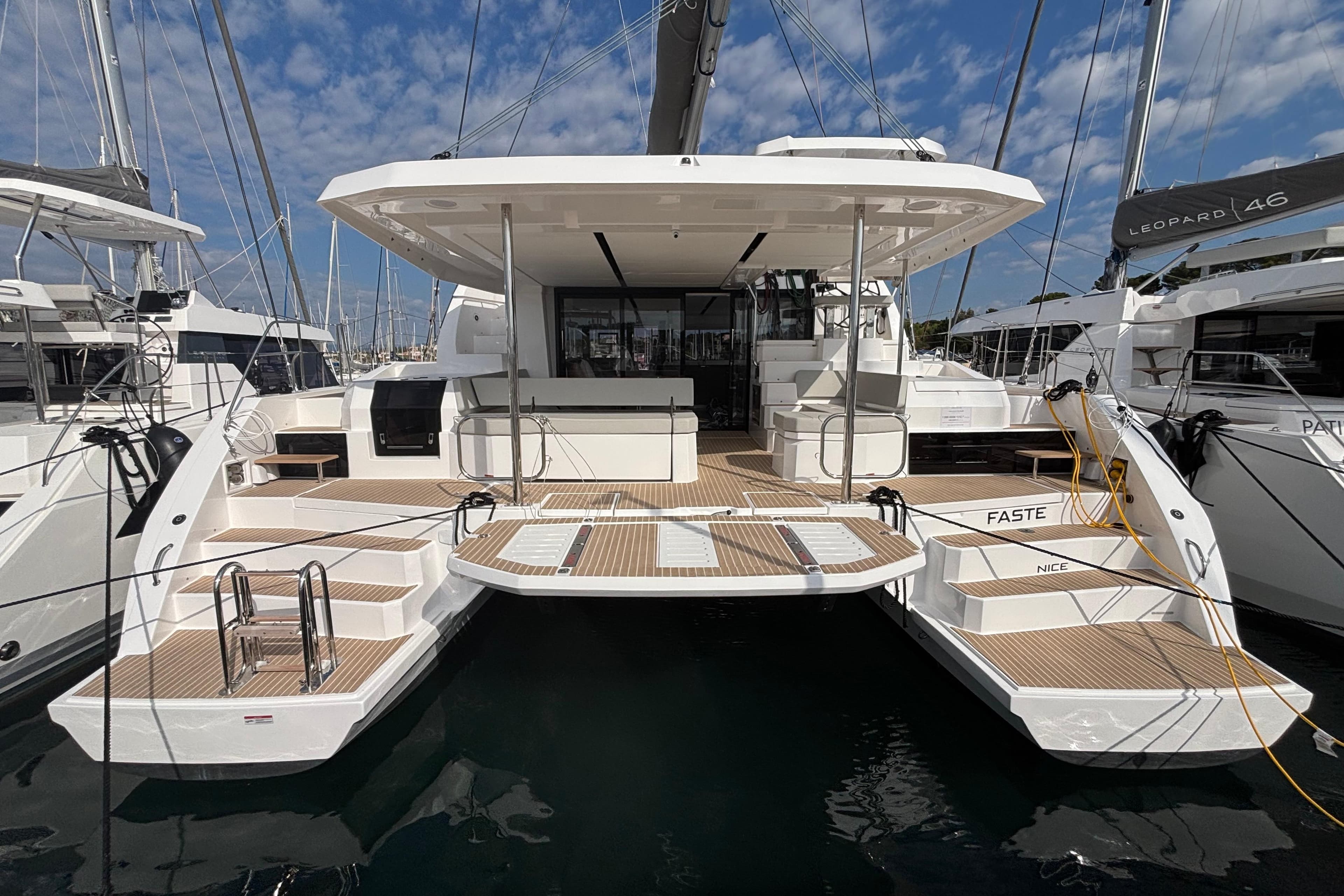 2025 Leopard 52 yacht with spacious deck, docked in marina under blue sky.
