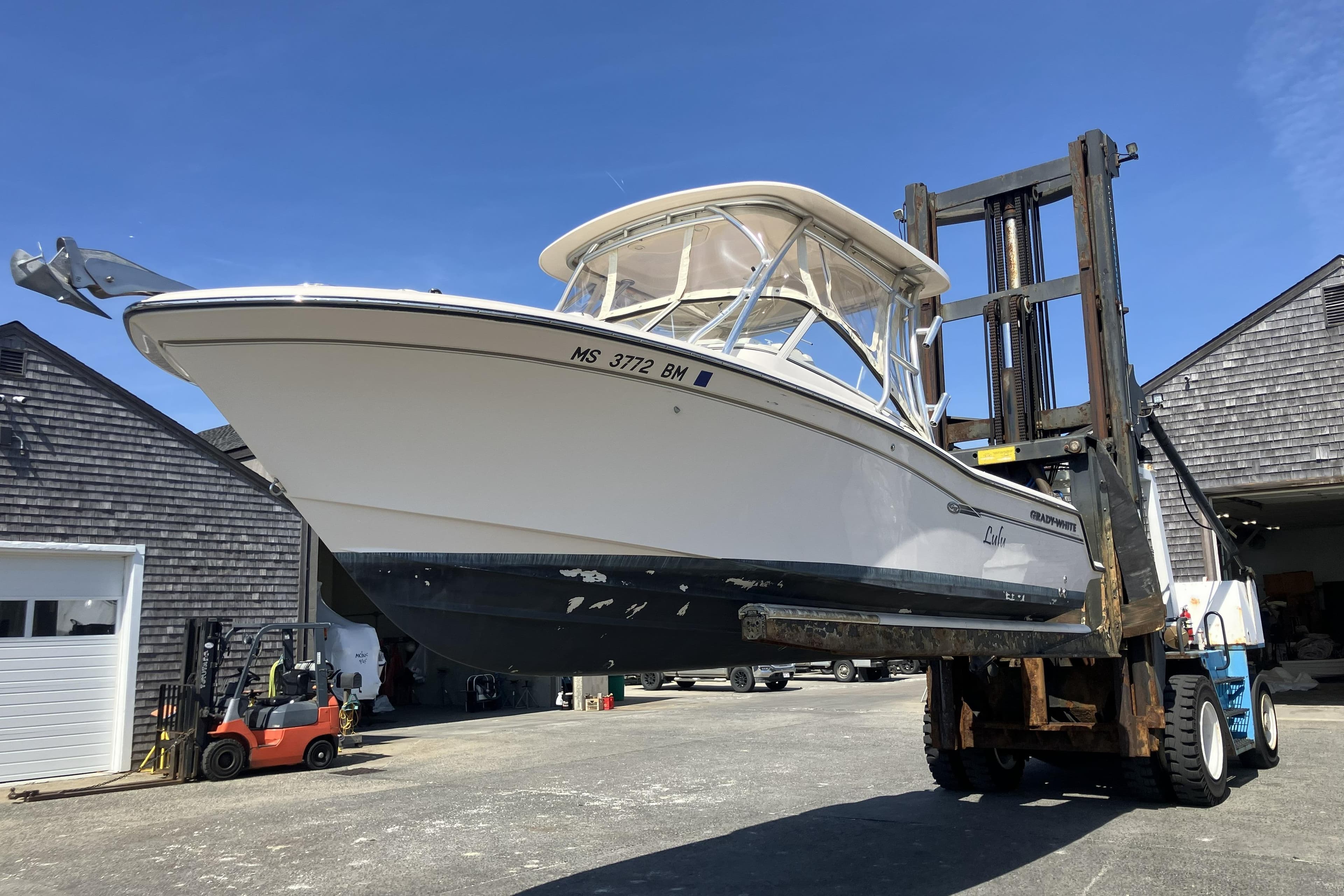 2019 Grady-White Freedom 235 boat lifted by forklift in marina.