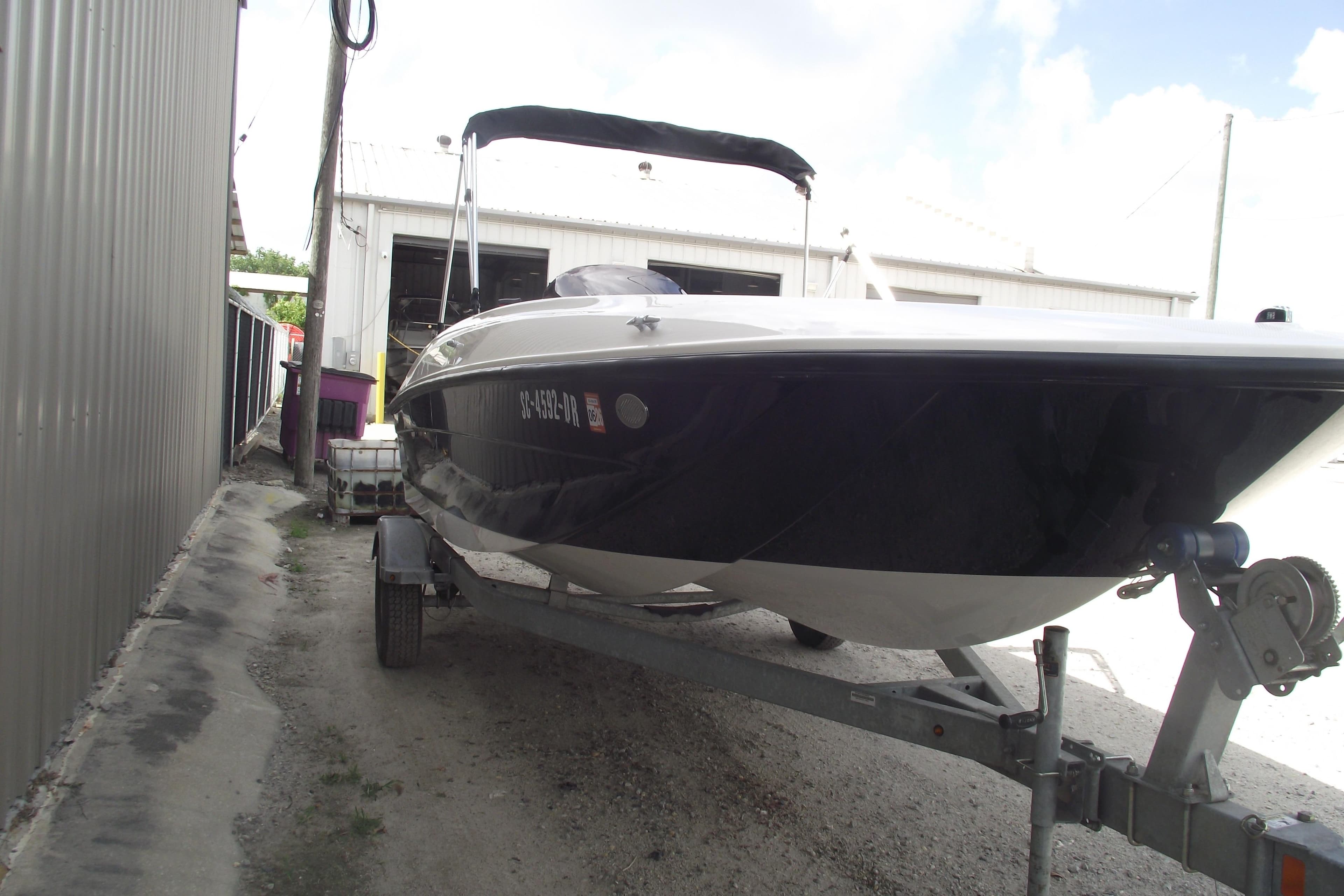 2021 Bayliner Element E18 boat on trailer near a metal building.