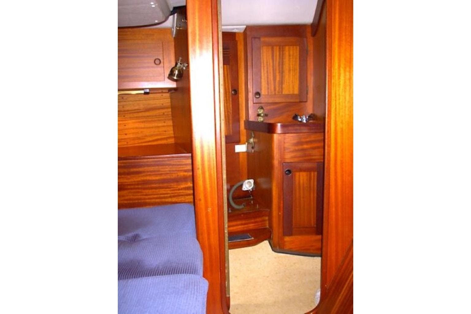 Interior of 1985 Sweden Yachts 41, featuring wooden cabinetry and blue upholstery.