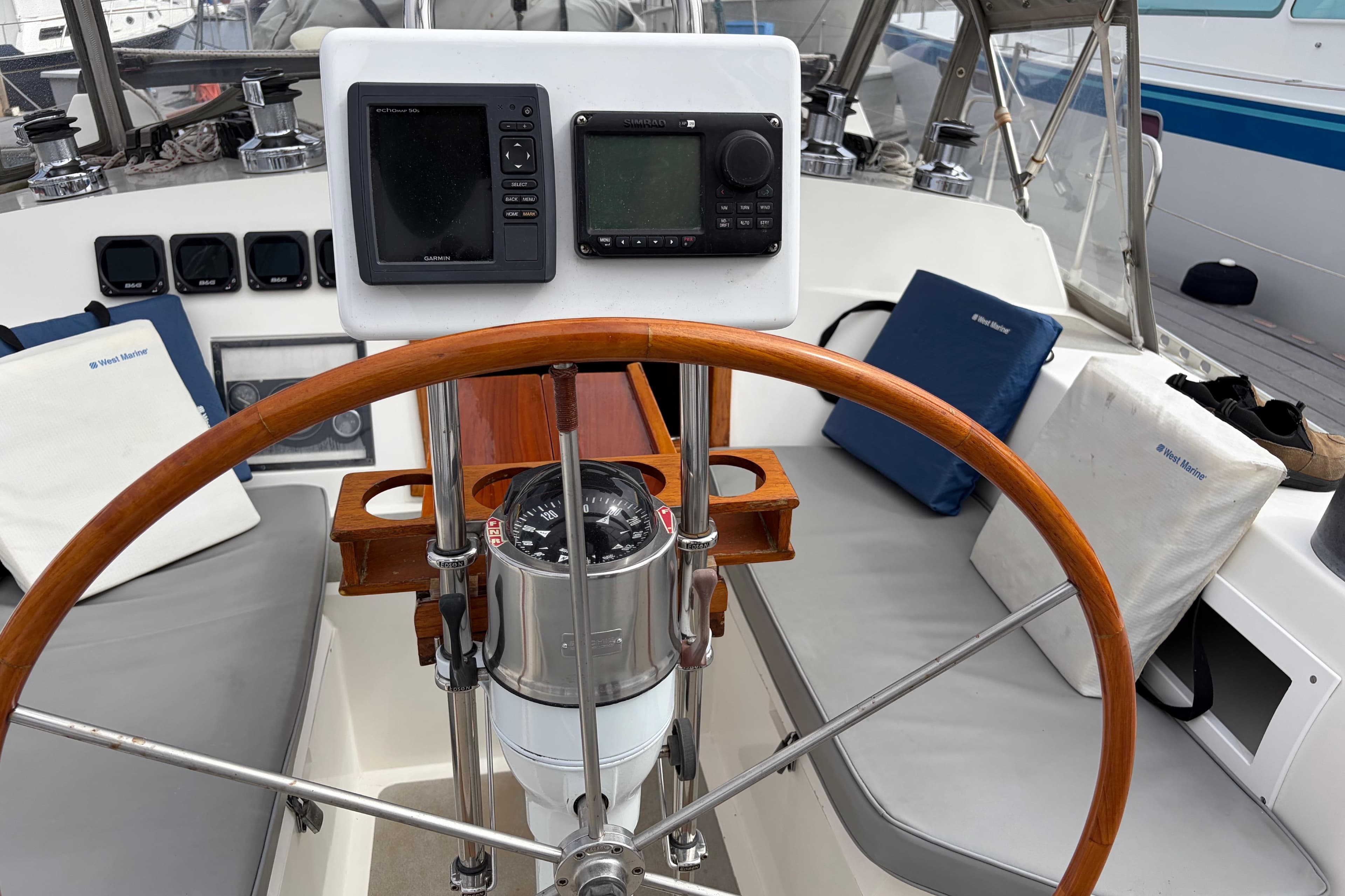 Cockpit of 1986 Nordic 44 sailboat with wooden wheel and navigation instruments.