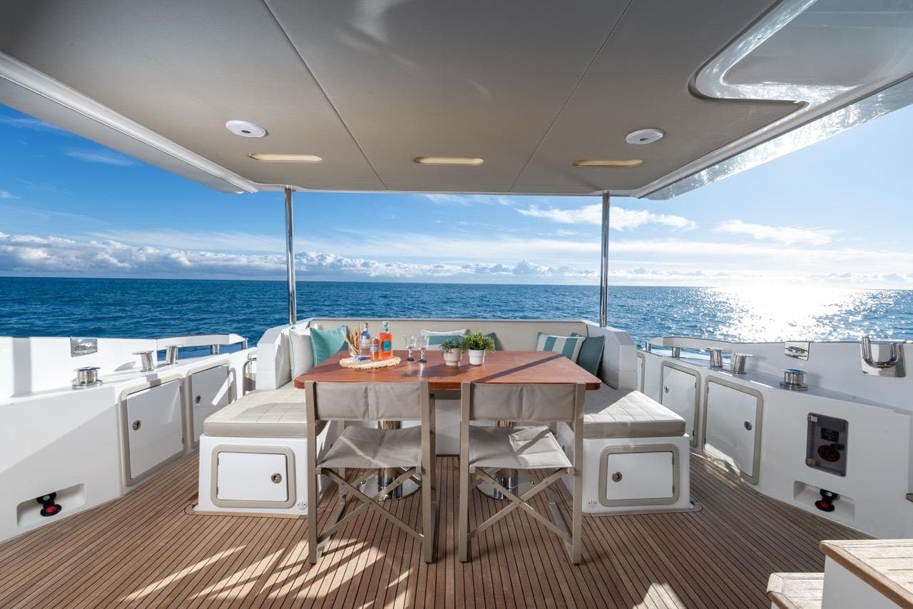 Luxurious 2016 Azimut 66 yacht deck with ocean view and elegant dining setup.