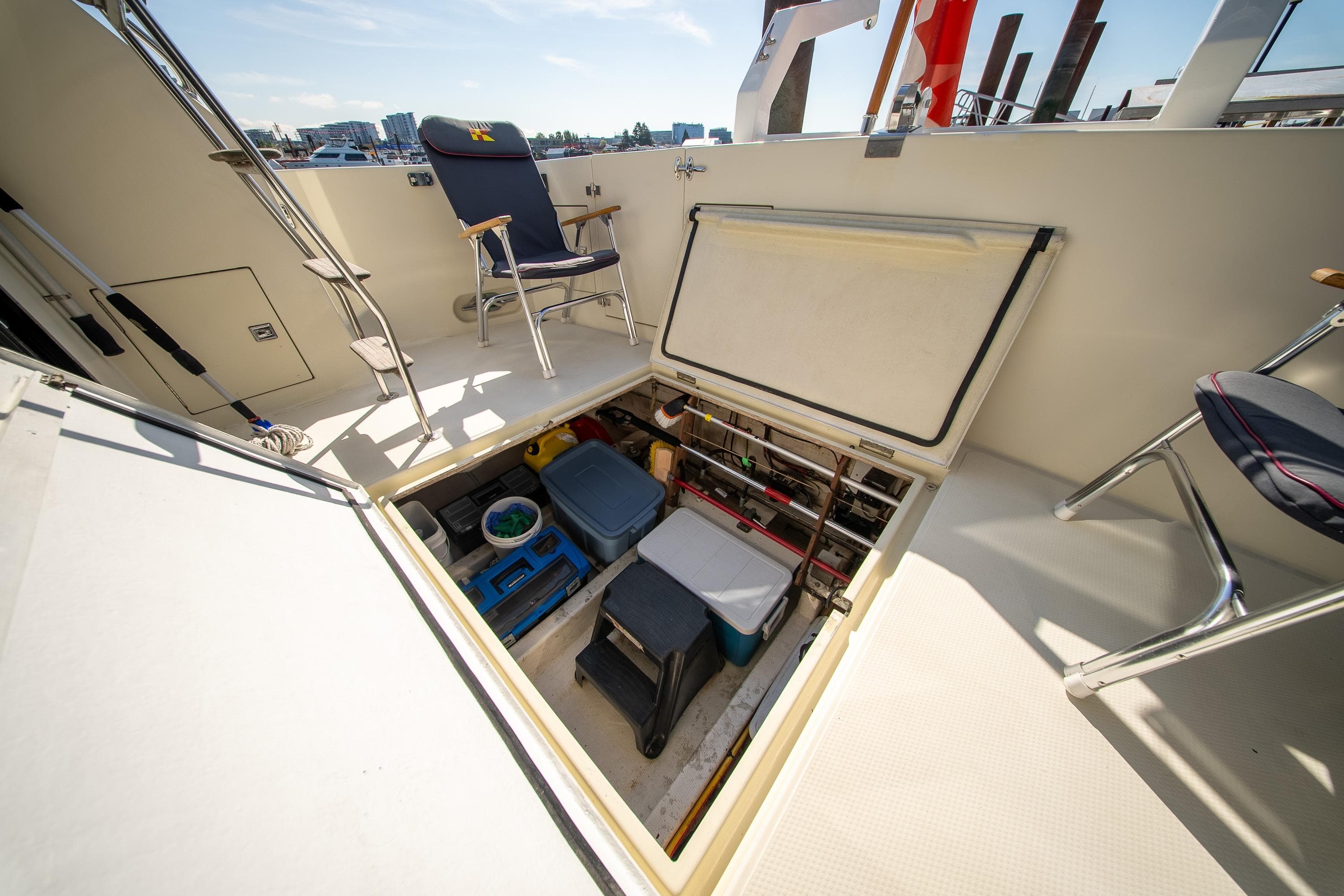 1990 Tollycraft 44 Sedan yacht deck with open storage hatch and chairs.