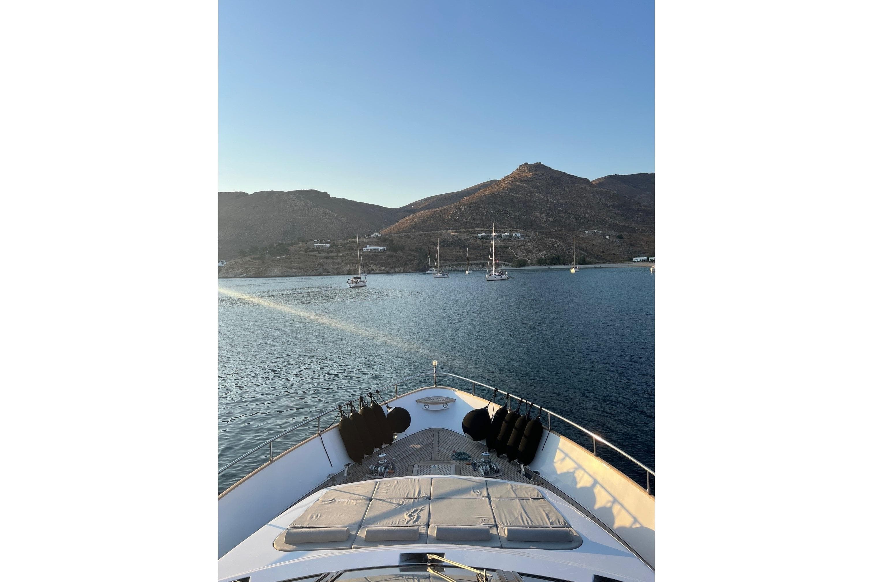1999 Diano 26 yacht in serene bay with mountains.