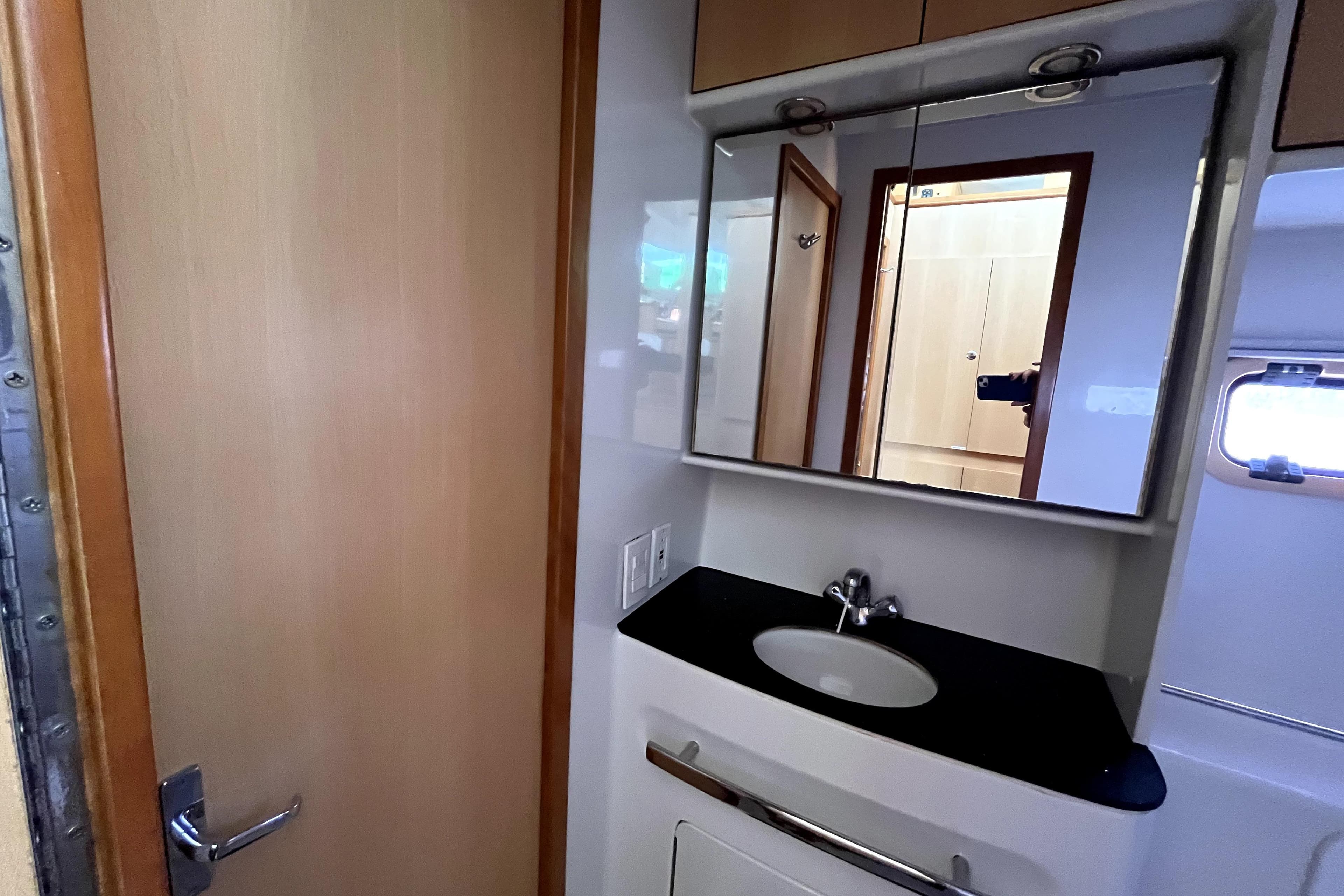 Bathroom interior of 2009 Kelsall 58 KSS yacht with mirror and sink.