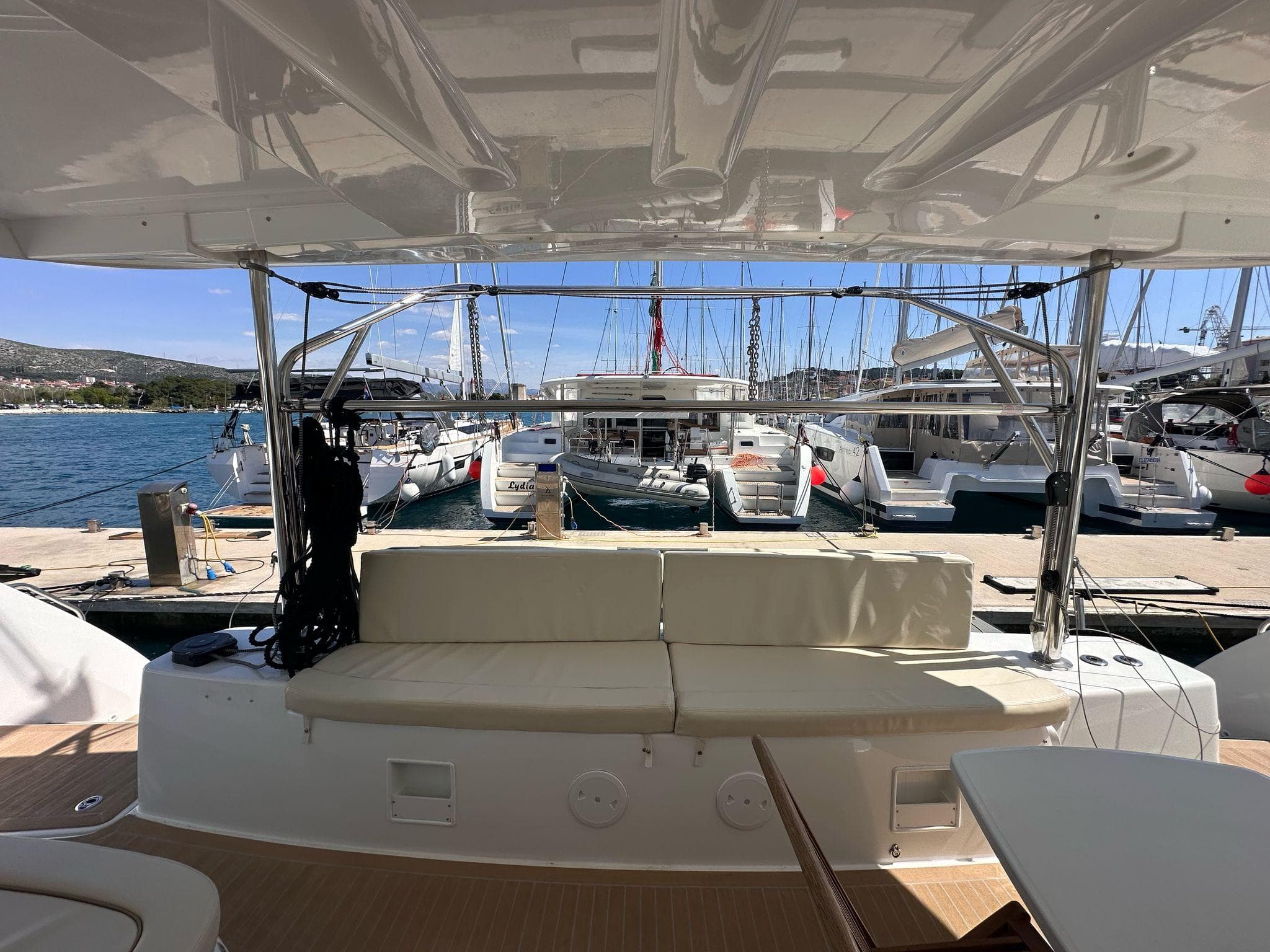 2024 Lagoon 46 yacht interior with docked boats in marina background.