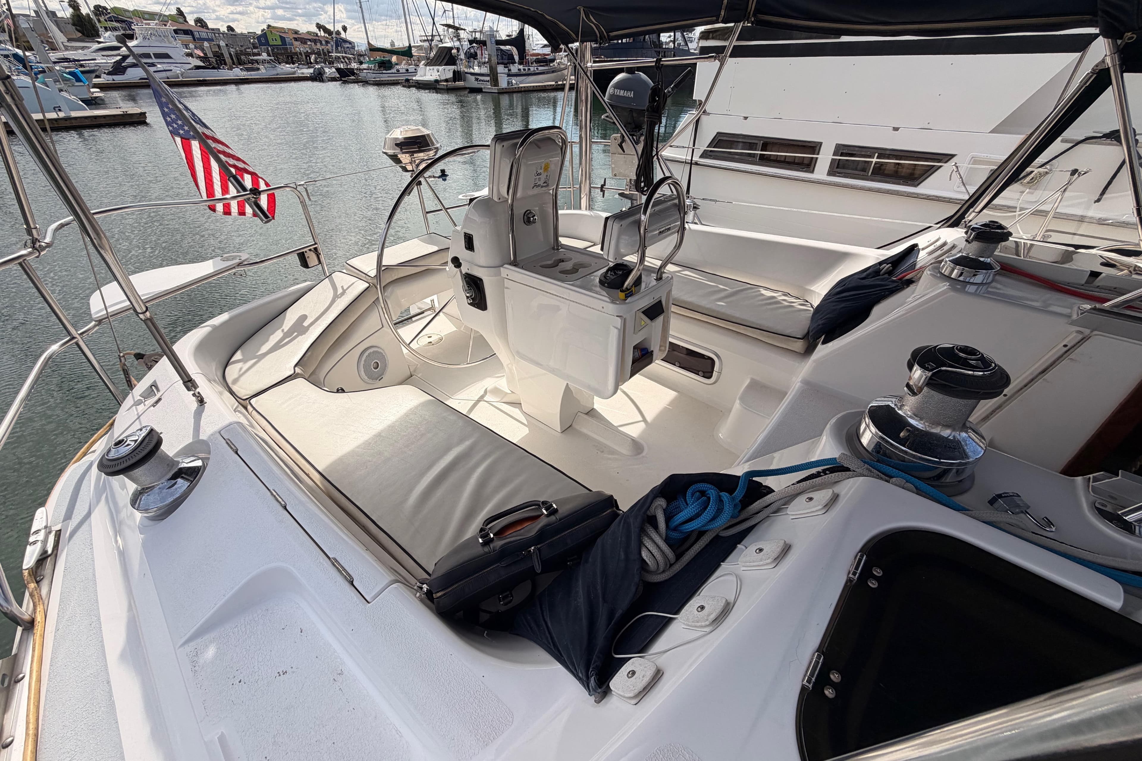 Cockpit of 1998 Hunter Legend 40.5 sailboat docked in marina, featuring steering wheel and seating.