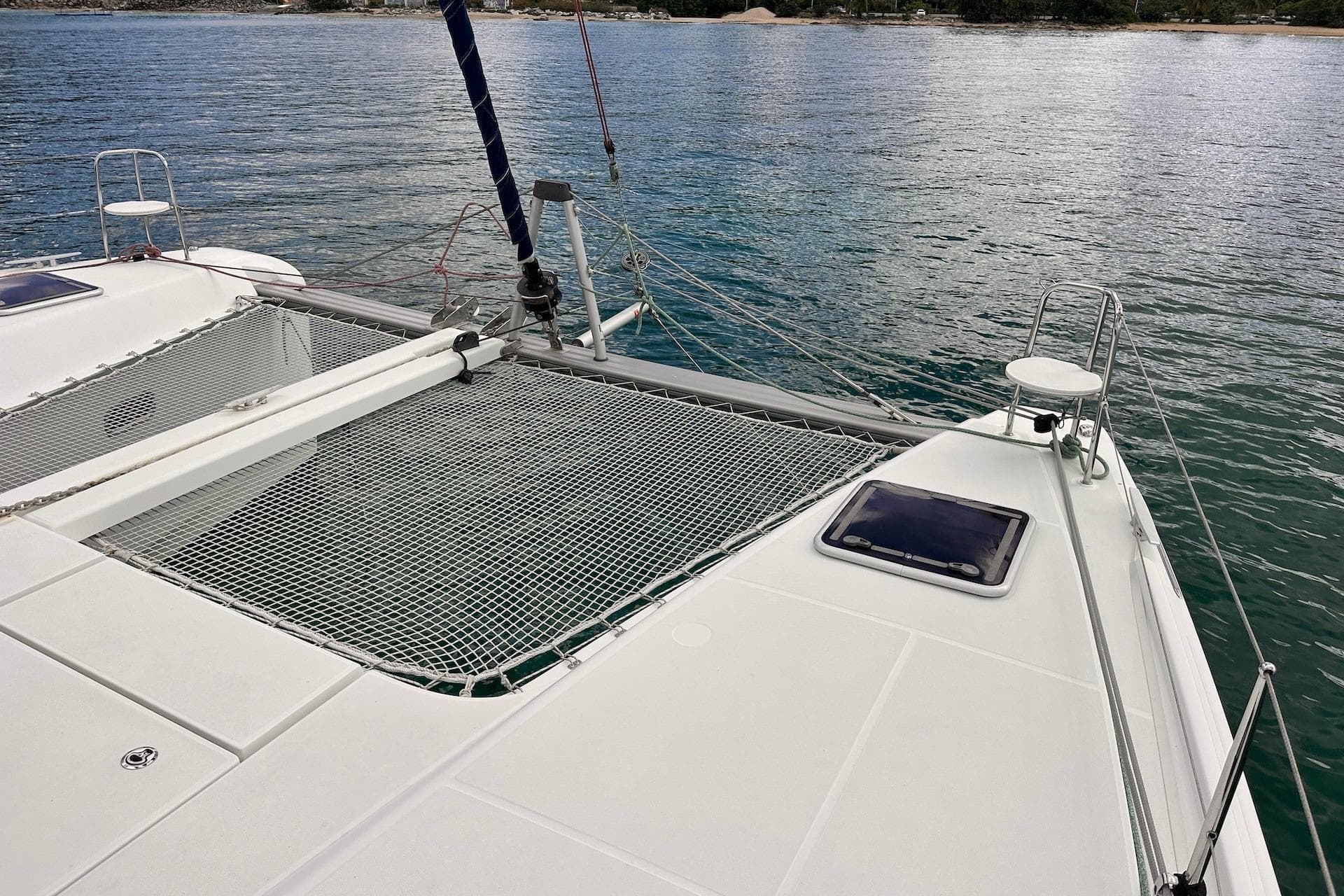2016 Lagoon 42 catamaran deck with netting, anchored on calm waters.