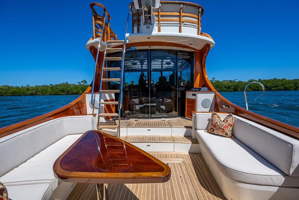 Luxurious 2021 Hinckley Talaria 55 Flybridge MKII yacht with elegant seating and scenic water view.