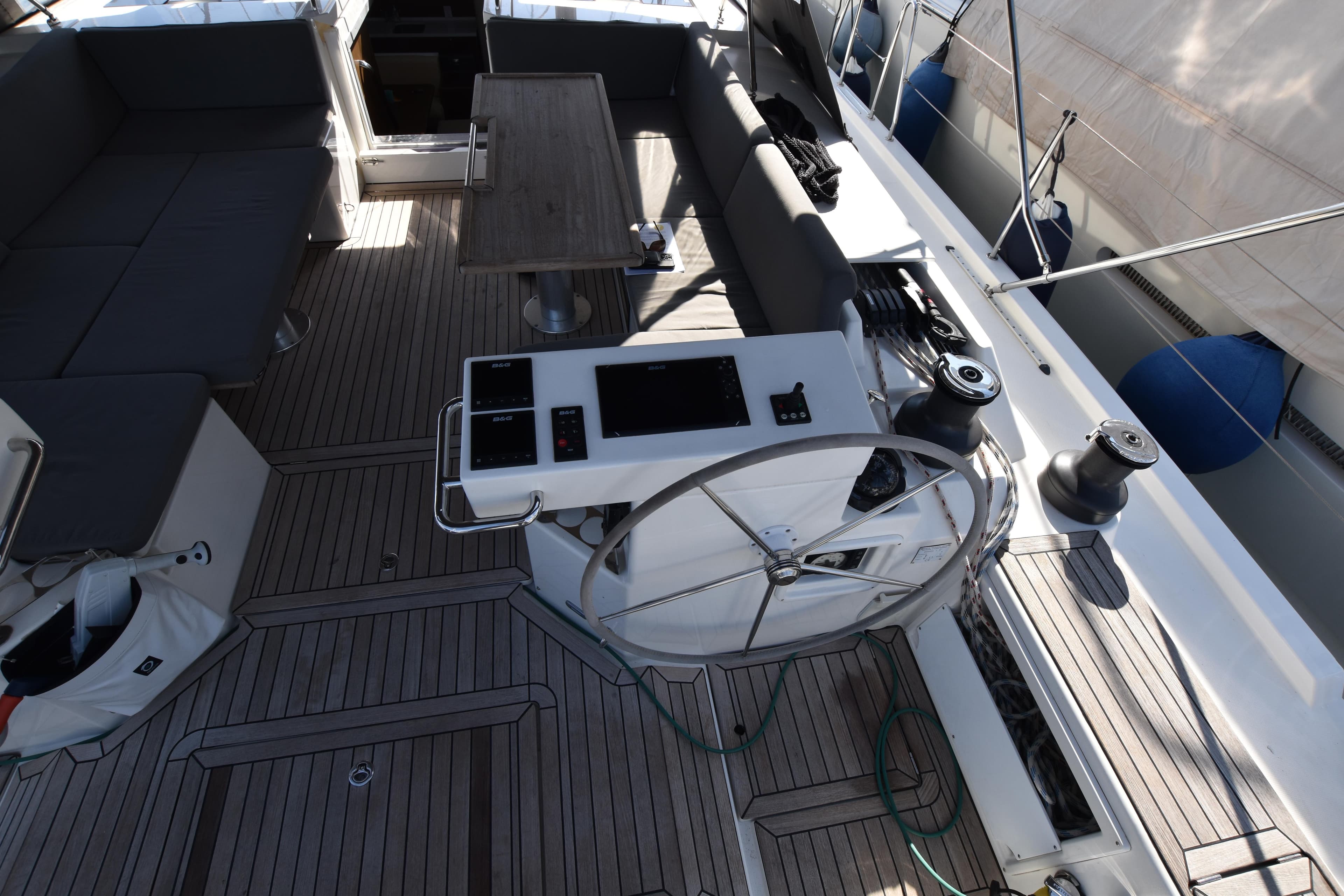 Luxurious Bavaria C57 yacht cockpit with modern steering and seating, 2020 model.