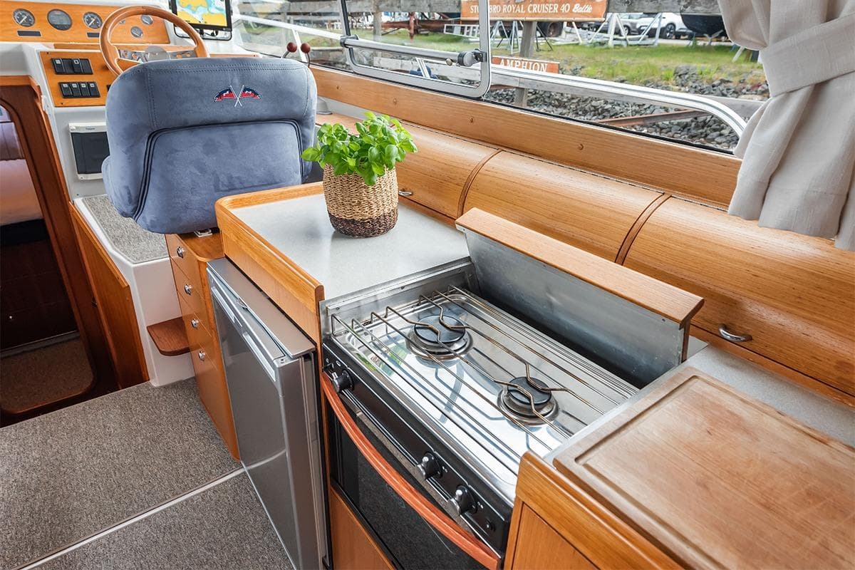 Interior of 2000 Nimbus 380 Carisma boat with compact kitchen and steering area.