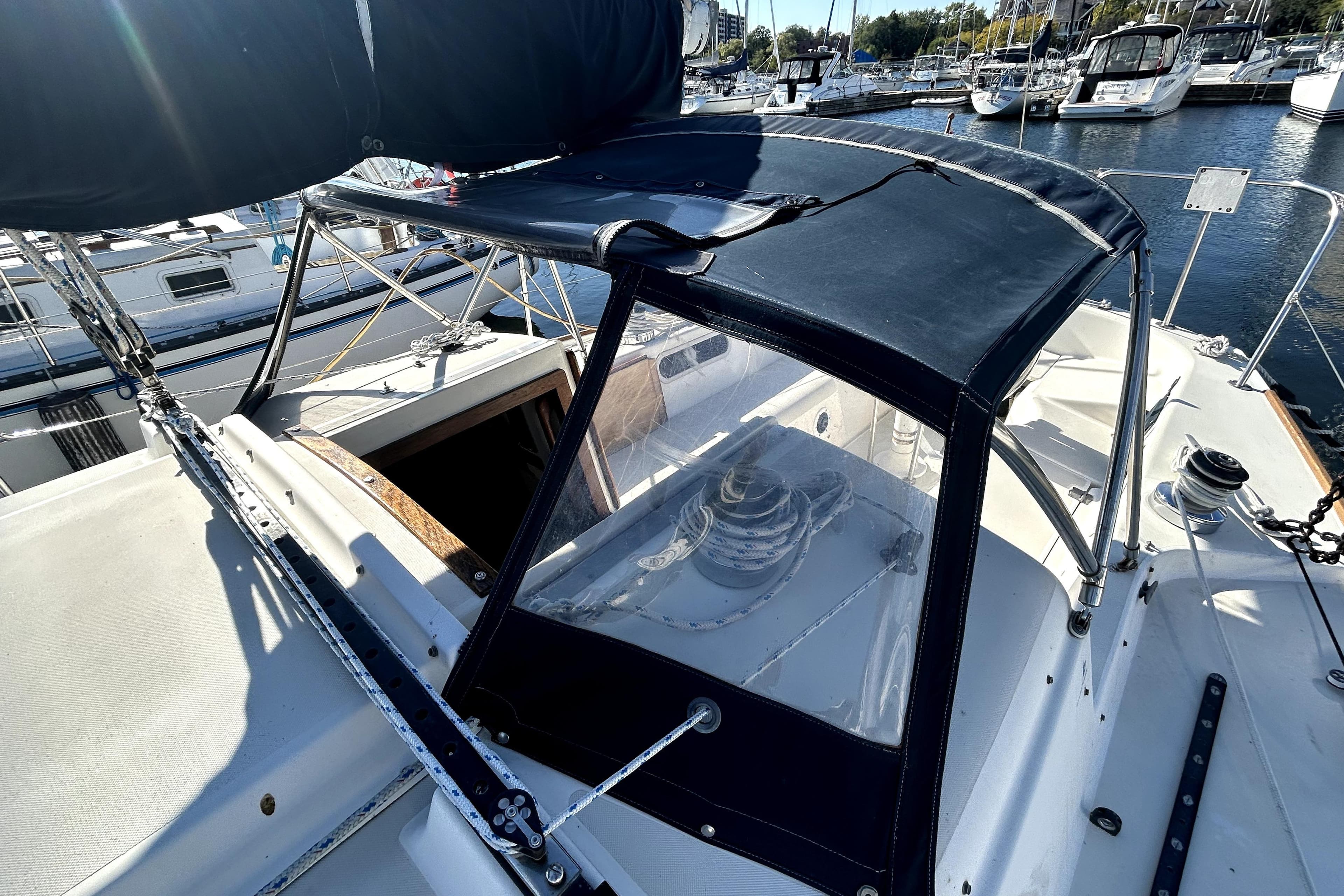 1983 Pearson 34 sailboat cockpit with protective canopy, docked in a marina.