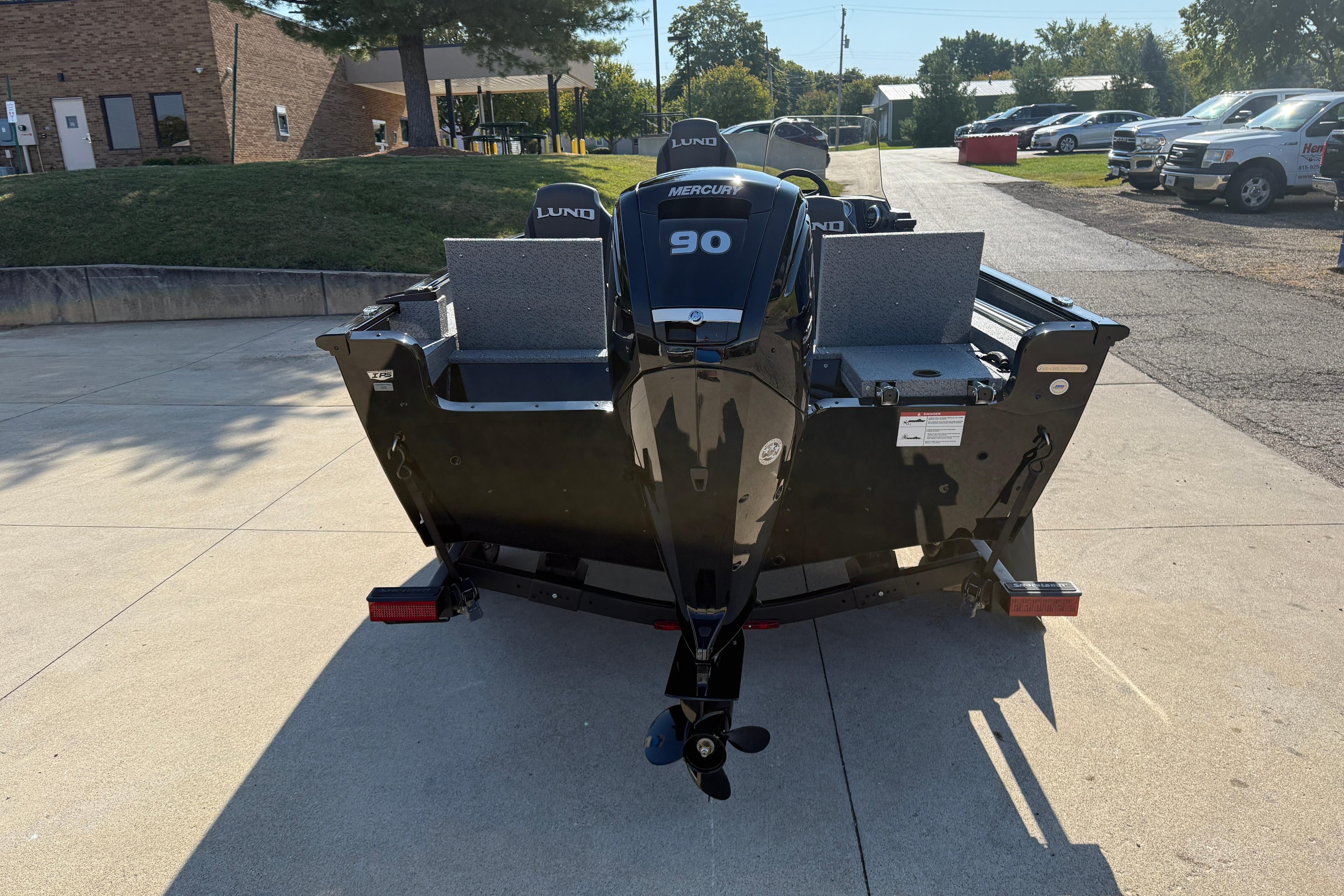 2026 Lund 1675 Adventure SS boat with Mercury 90 engine, parked outdoors.
