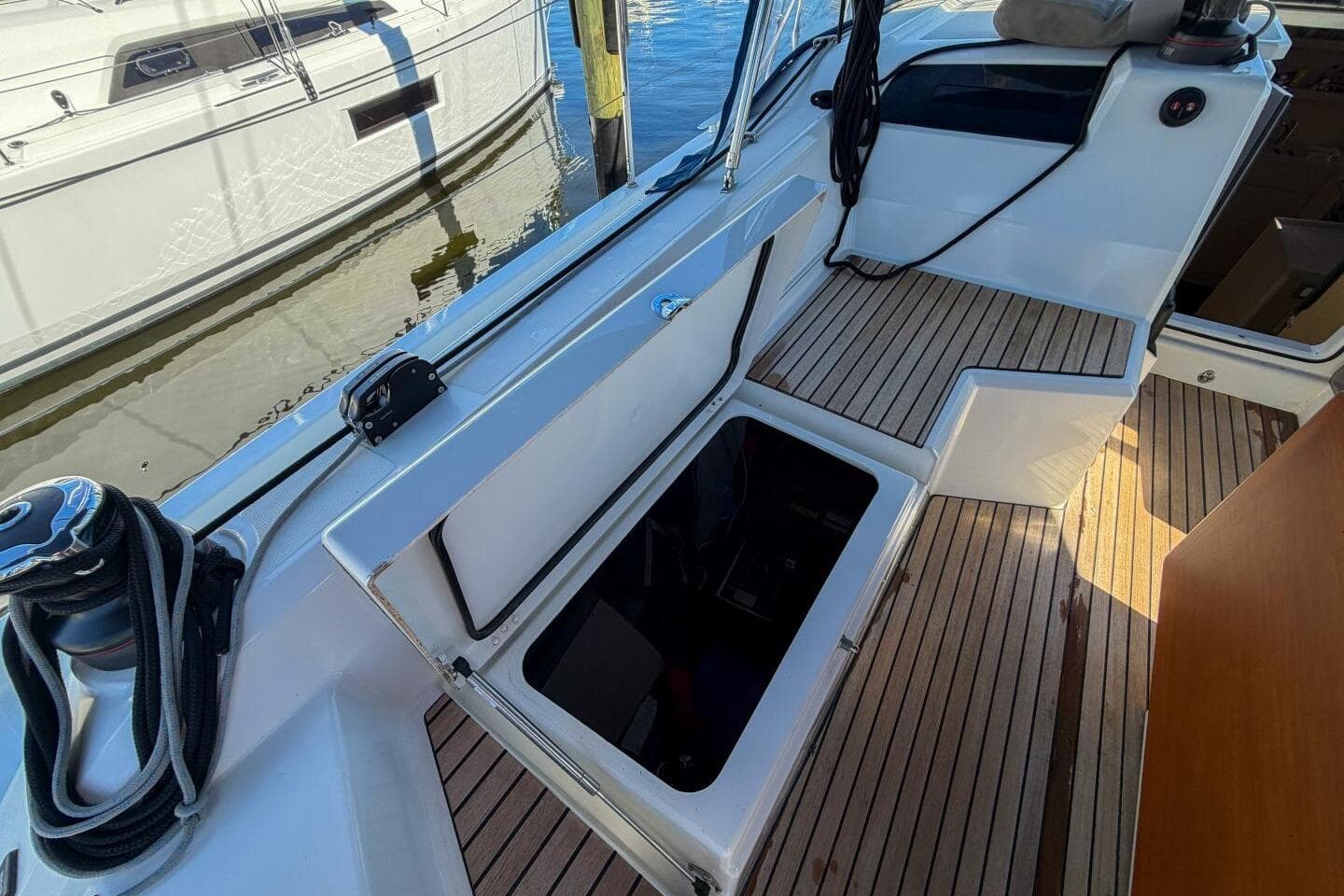 2022 Beneteau Oceanis 40.1 yacht cockpit with open storage compartment and teak flooring.