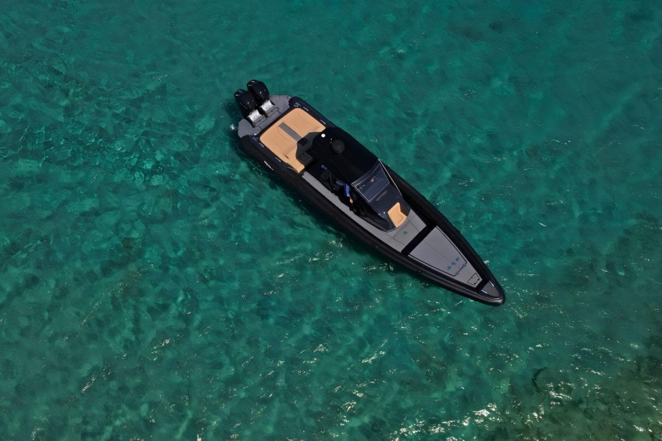 Aerial view of 2022 Ribco Venom 44 boat on clear turquoise water.