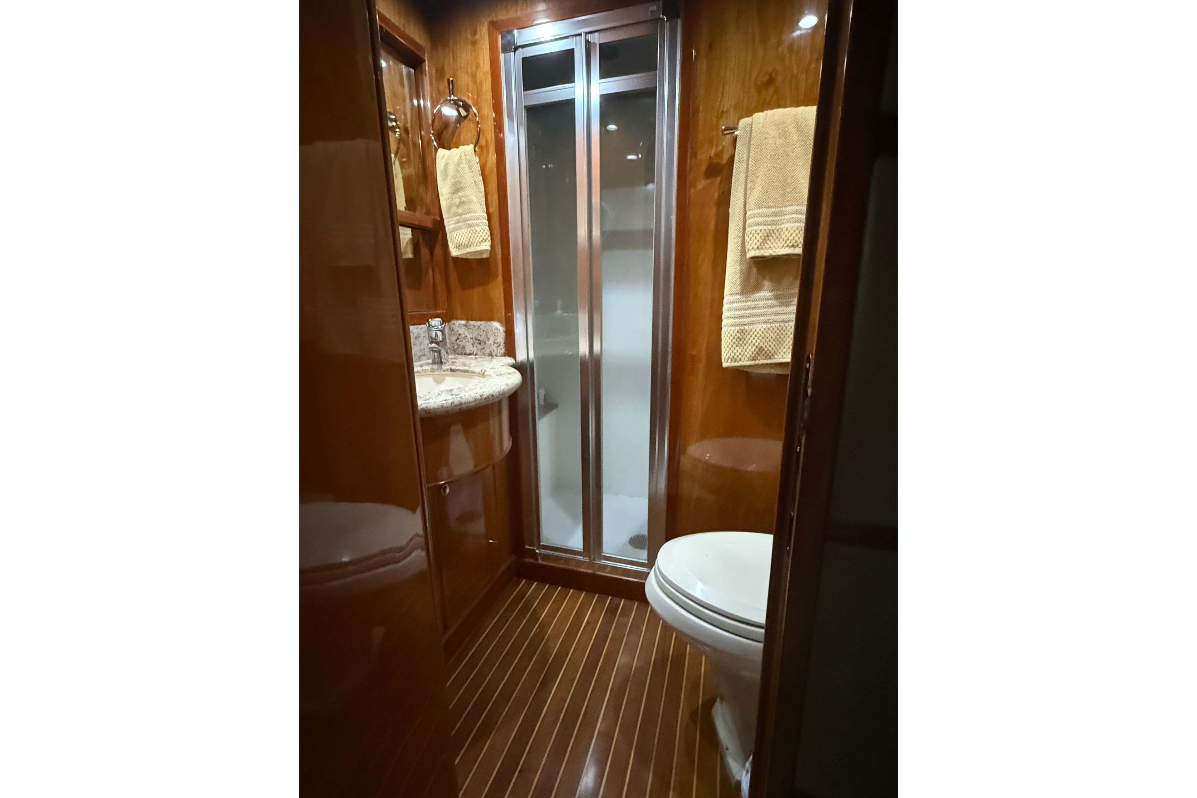 Luxurious bathroom in 2001 Hargrave 94 yacht with wood paneling and modern fixtures.