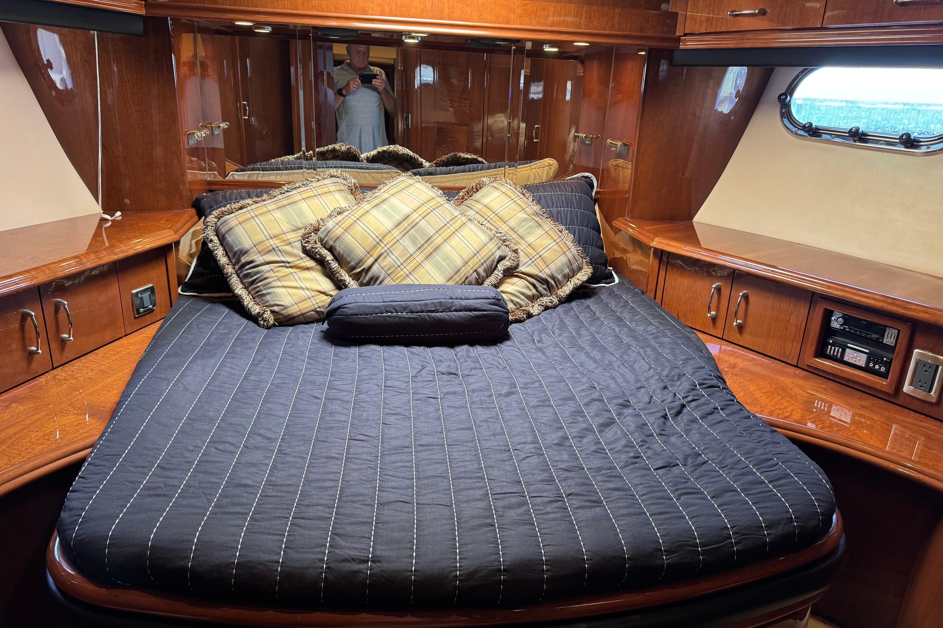 Luxurious 2006 Marquis 59 yacht bedroom with plush bedding and elegant wood cabinetry.