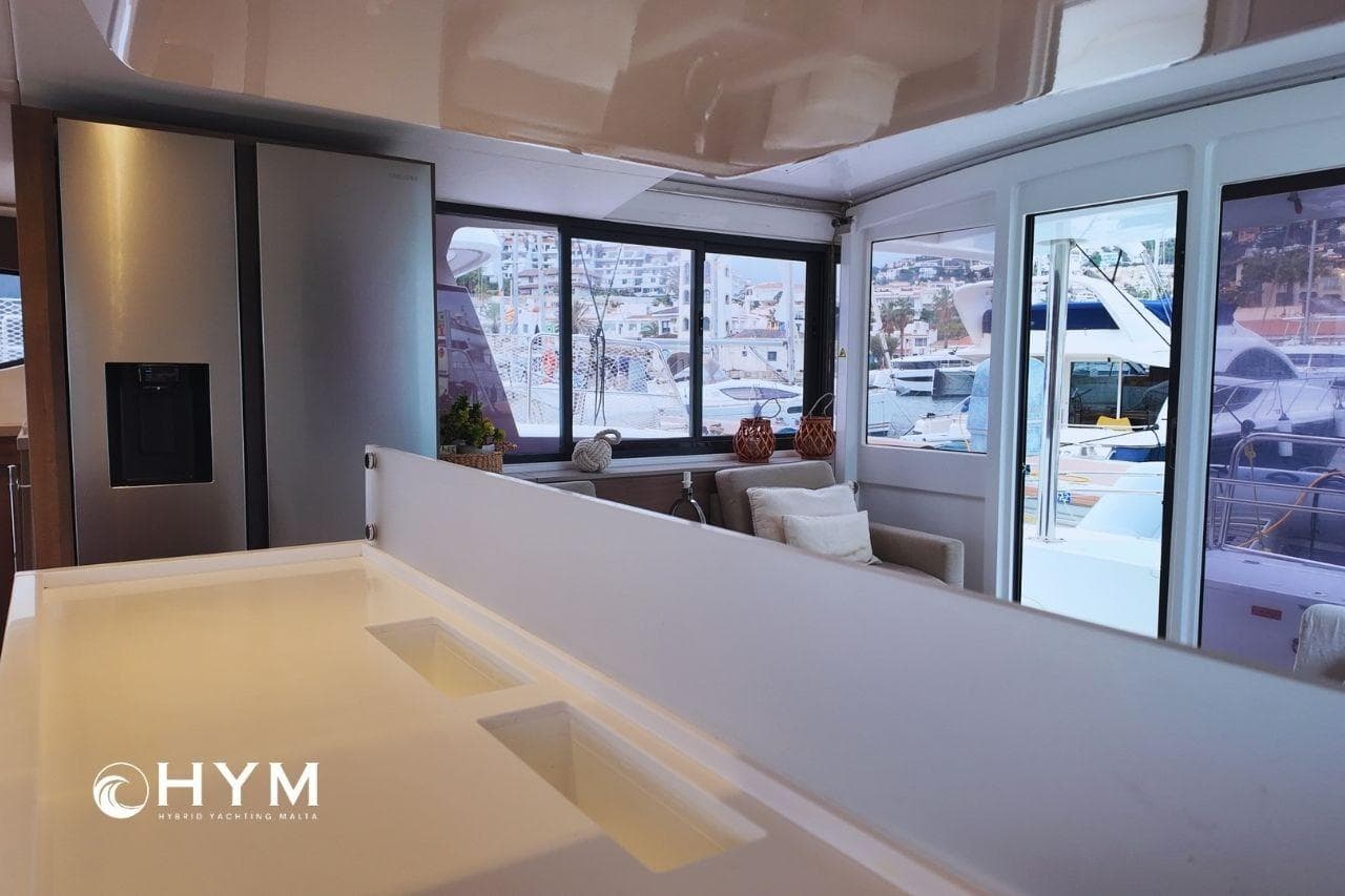 Luxurious interior of 2022 Bali 4.4 Open Space yacht with modern kitchen and marina view.