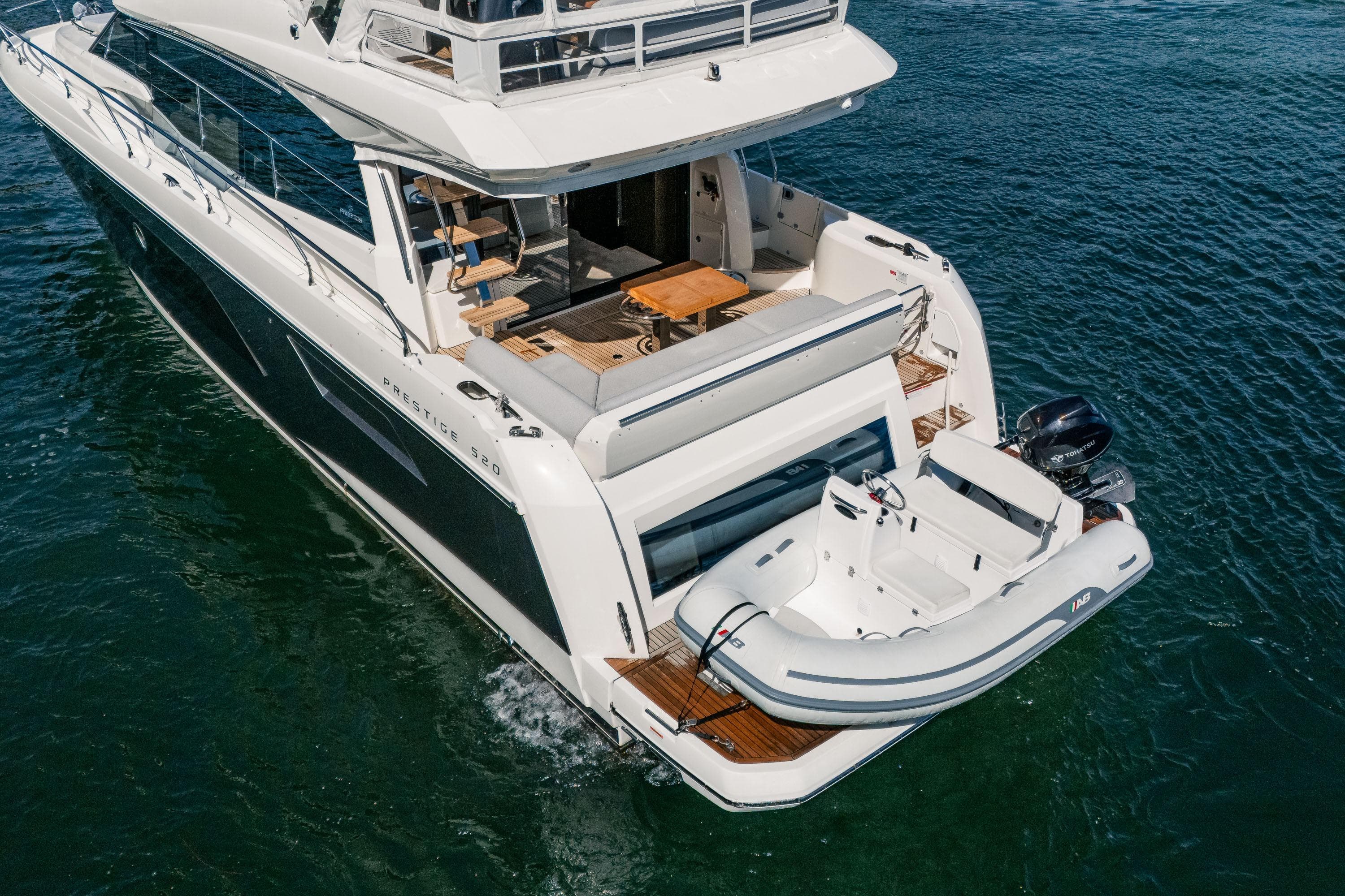 Luxury 2022 Prestige 520 yacht with tender, cruising on open water.