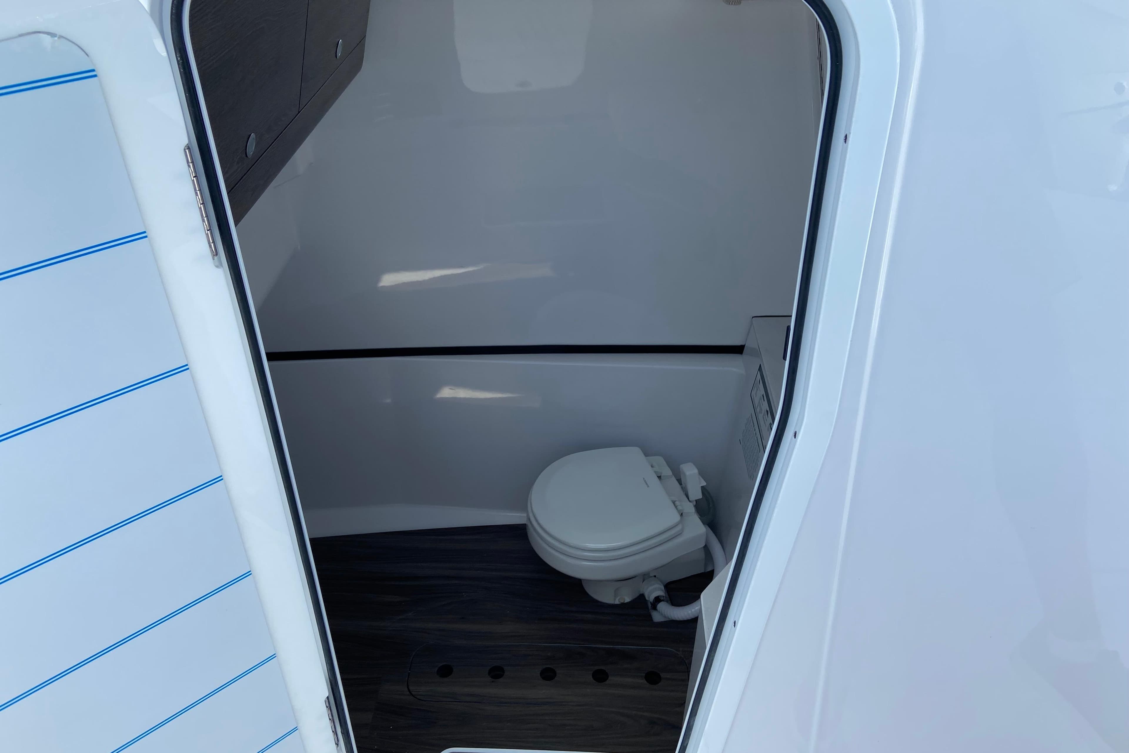 Interior view of 2026 Sportsman Heritage 321 Center Console boat's compact bathroom.