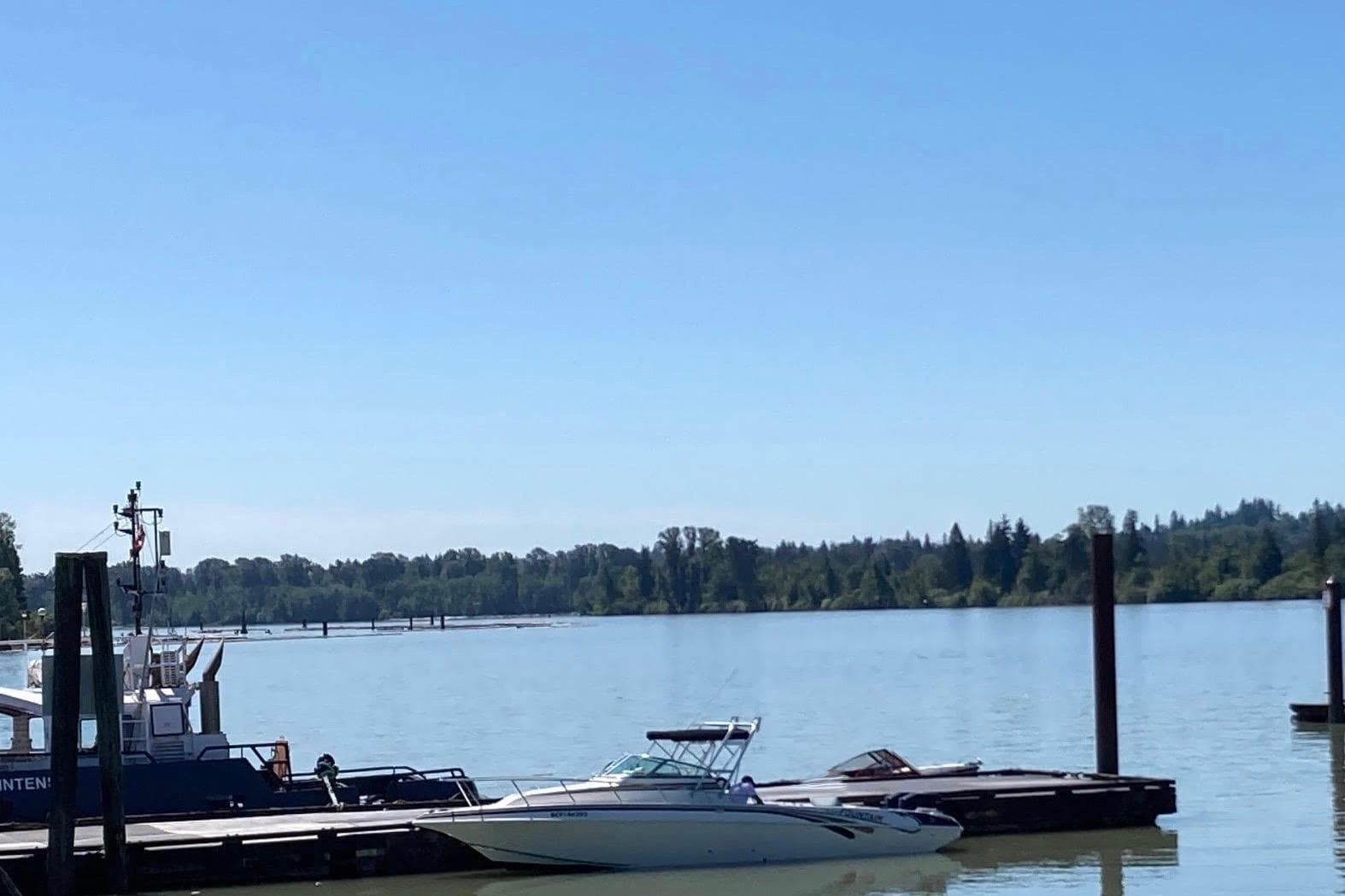 1998 Fountain 29 Sportfish Cruiser OB docked on a serene lake under clear blue skies.