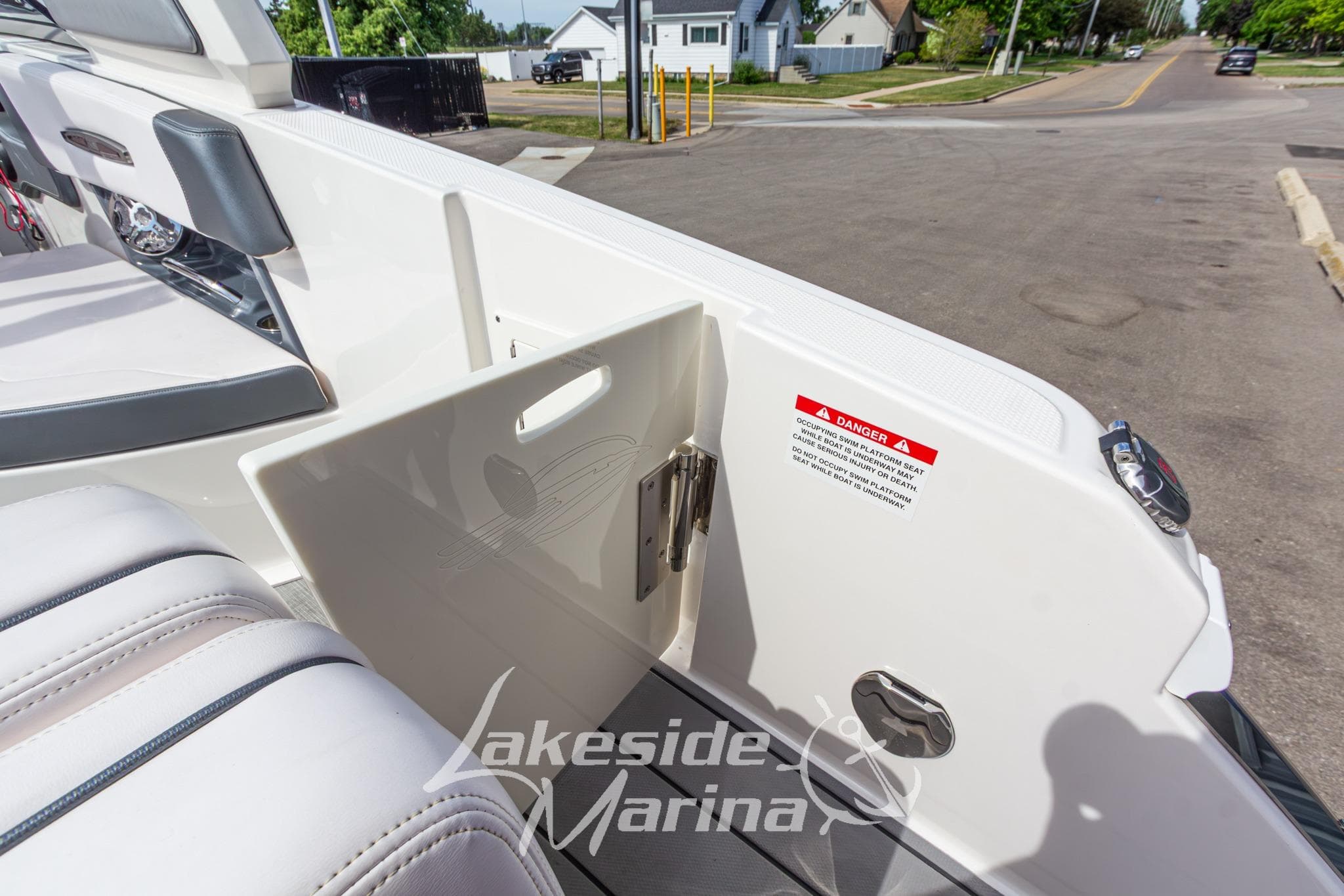 2021 Chaparral 287 SSX boat interior with open storage compartment and safety warning label.