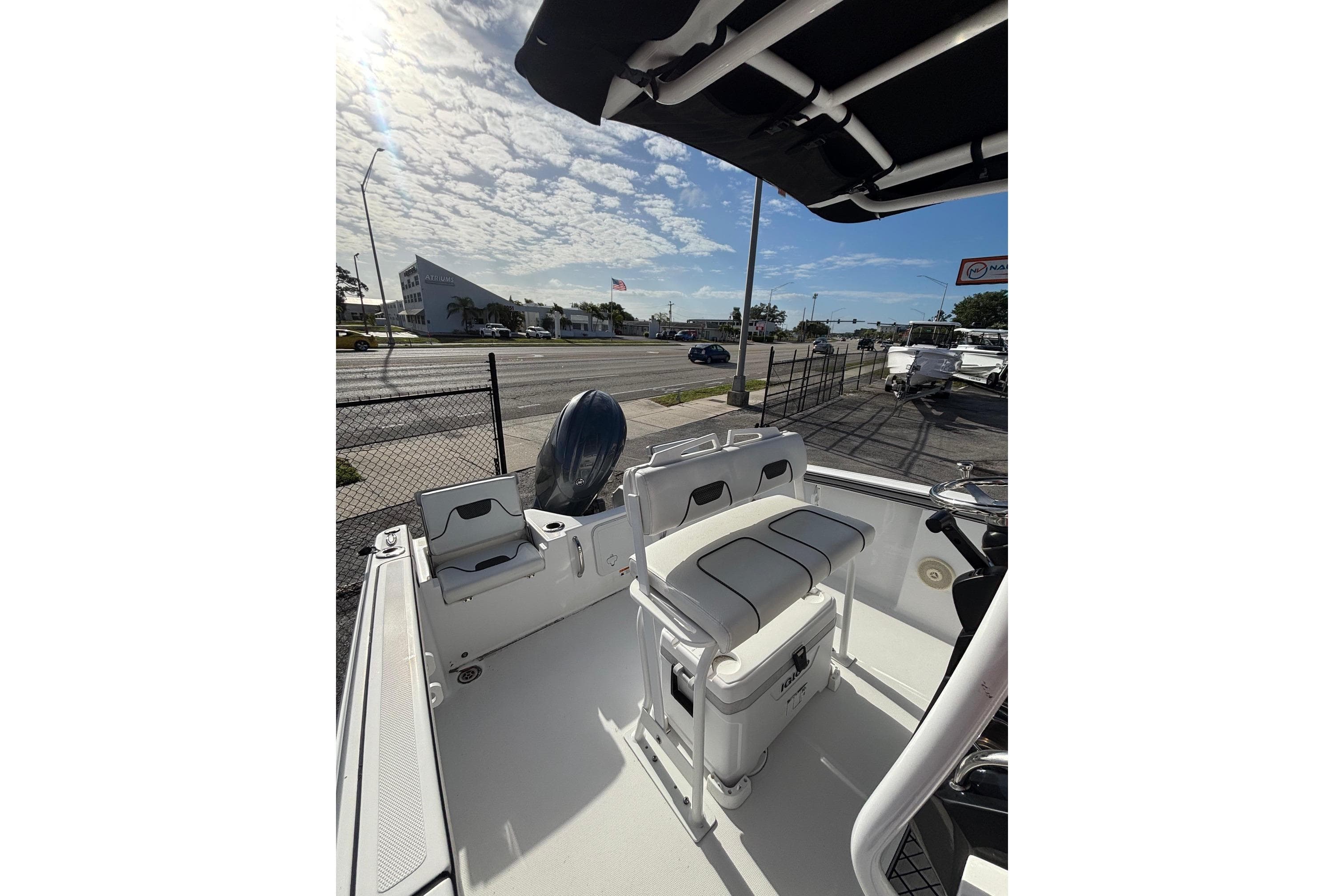 2024 Wellcraft 202 Fisherman boat interior with seating and motor, parked near a road.